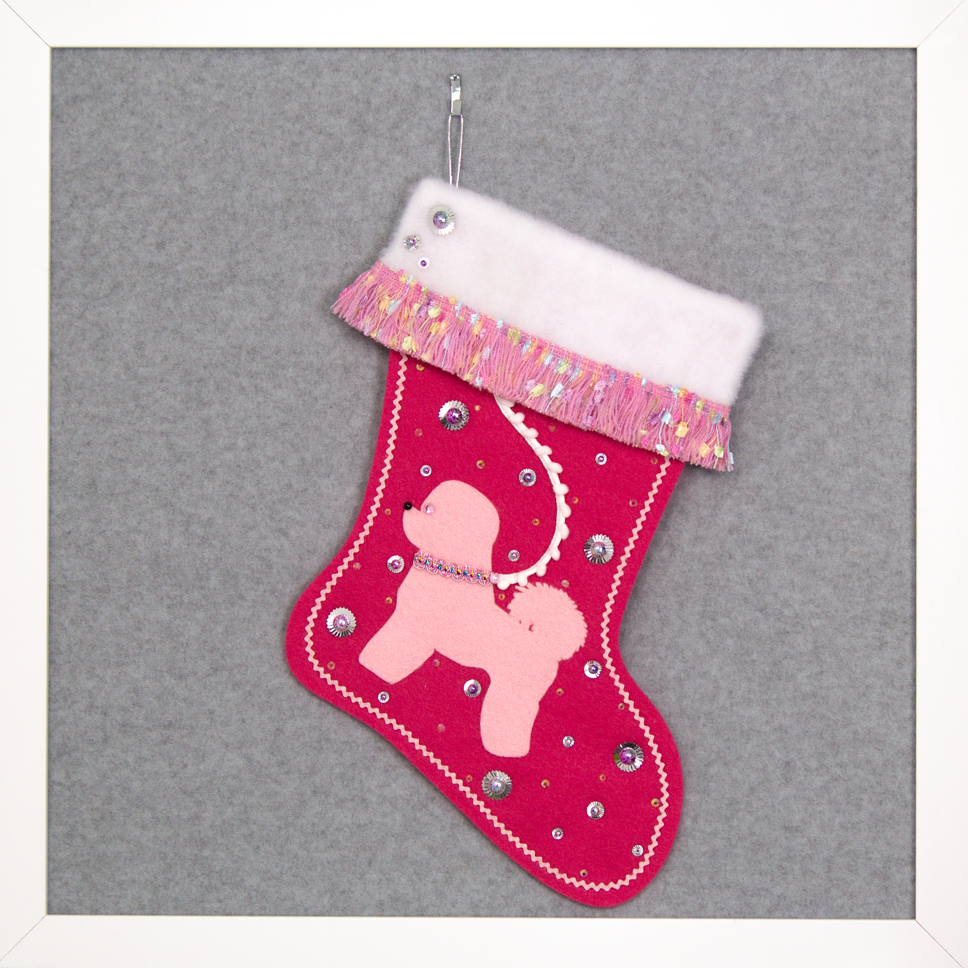 Bichon Frise dog in light pink felt Christmas stocking on candy pink felt with fringe, sequins, mini pom poms and decorations in multicolor and silver. (Front of stocking)