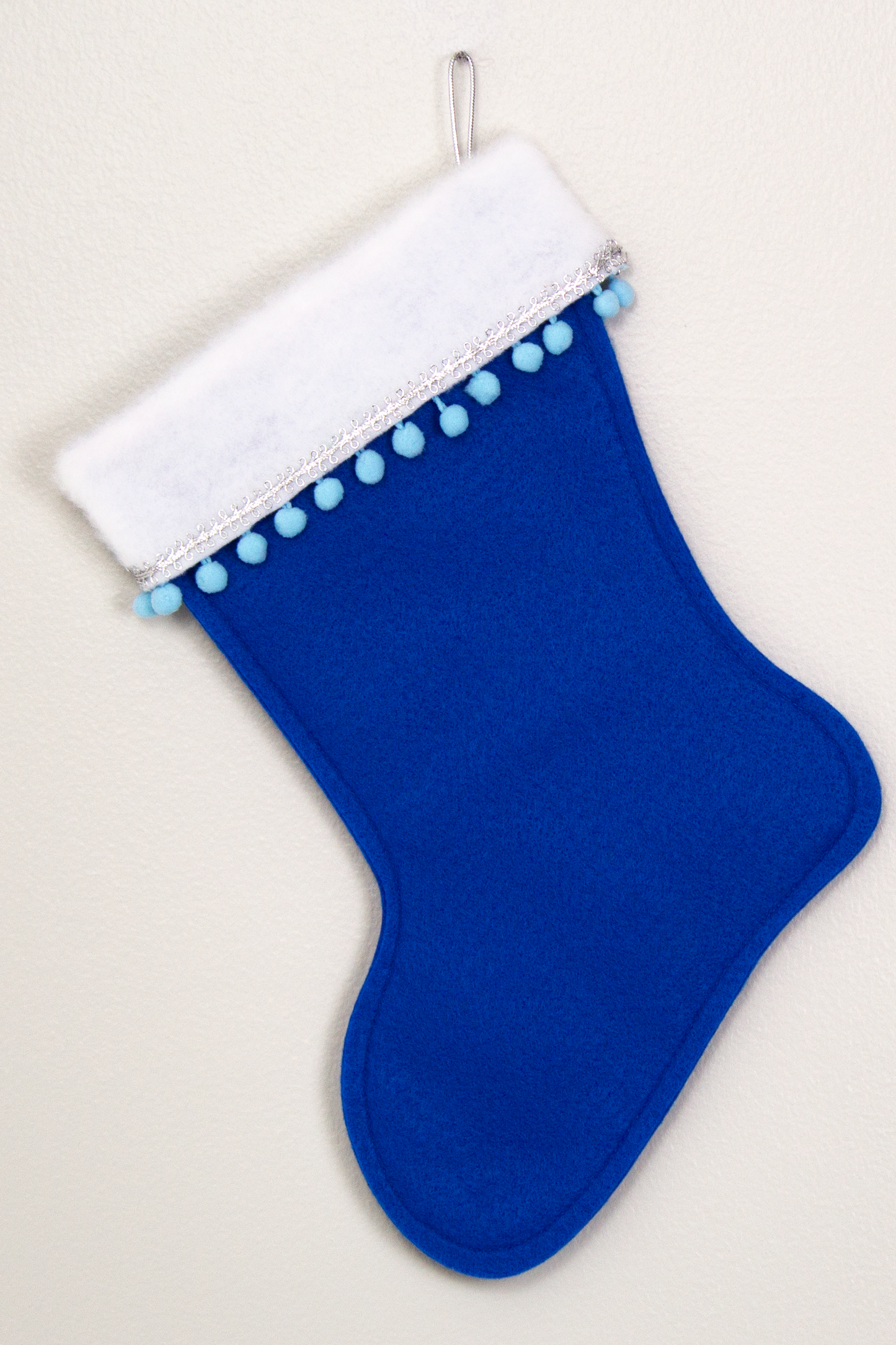 Christmas stocking on royal blue felt. (back Bichon Frise of stocking)