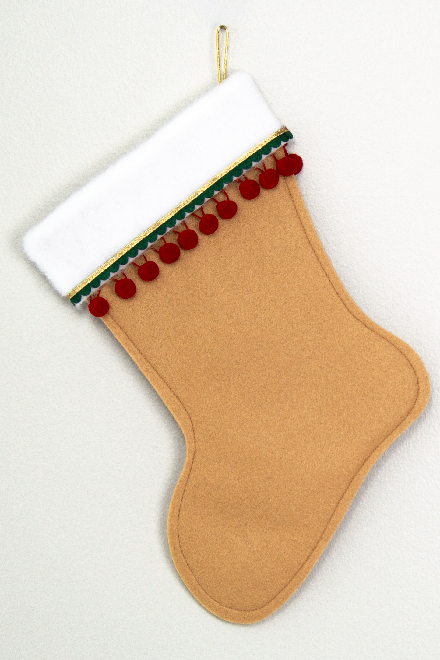 Tan felt handmade Christmas stocking with pom poms and decorated in red, dark green & gold. (back of Carousel Horse stocking)