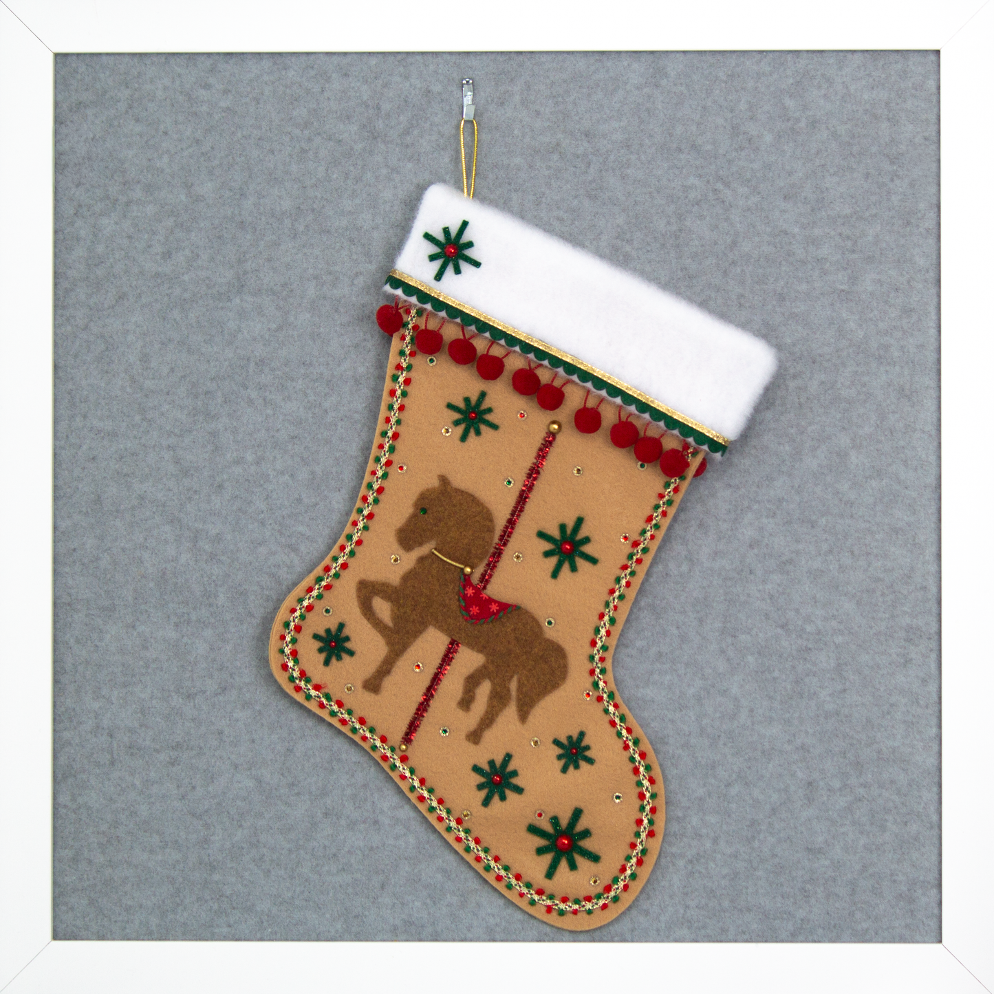 Copper felt horse on tan felt handmade Christmas stocking with pom poms, felt starbursts, tinsel pipe cleaner pole and decorated in red, dark green & gold. (front of Carousel Horse stocking)