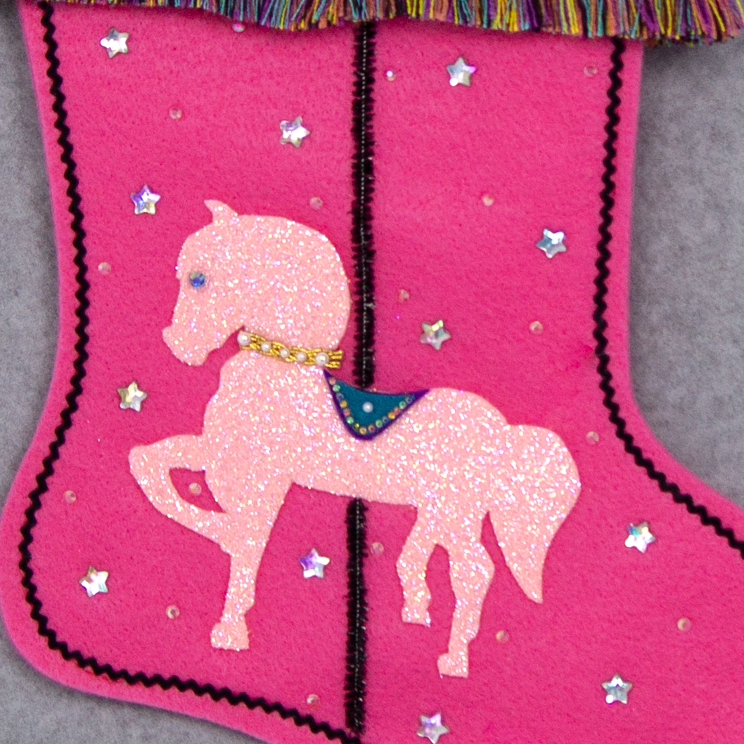Light pink glittered horse on candy pink felt handmade Christmas stocking with multicolor fringe, star rhinestones, tinsel pipe cleaner pole and decorations in white, clear, holographic, turquoise, purple, black & gold. (front of Carousel Horse stocking - close up detail of horse)