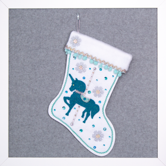 Turquoise felt glittered unicorn on a white glitter felt handmade Christmas stocking with pom poms, snowflake buttons and decorations in aqua, turquoise, white & silver. (front of Carousel Unicorn stocking)