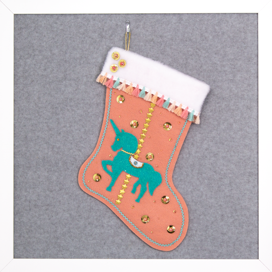 Aqua glittered unicorn on coral felt handmade Christmas stocking with tassel fringe, stars, sunburst sequins and decorated in gold, coral, aqua & multicolored pastels. (front of Carousel Unicorn stocking)