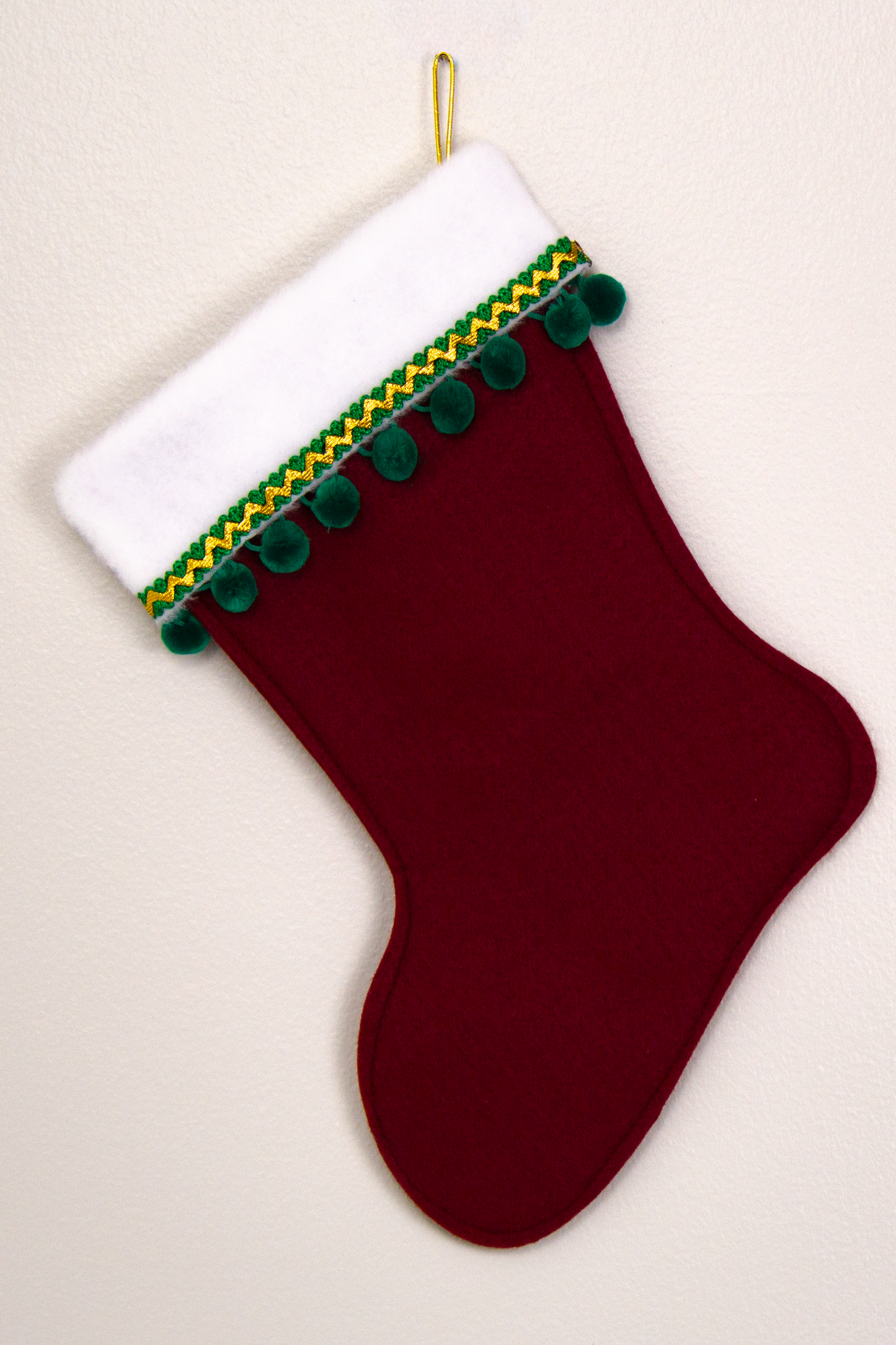 Ruby red felt handmade Christmas stocking with pom poms and decorated in green and gold. (back of Chihuahua dog stocking)