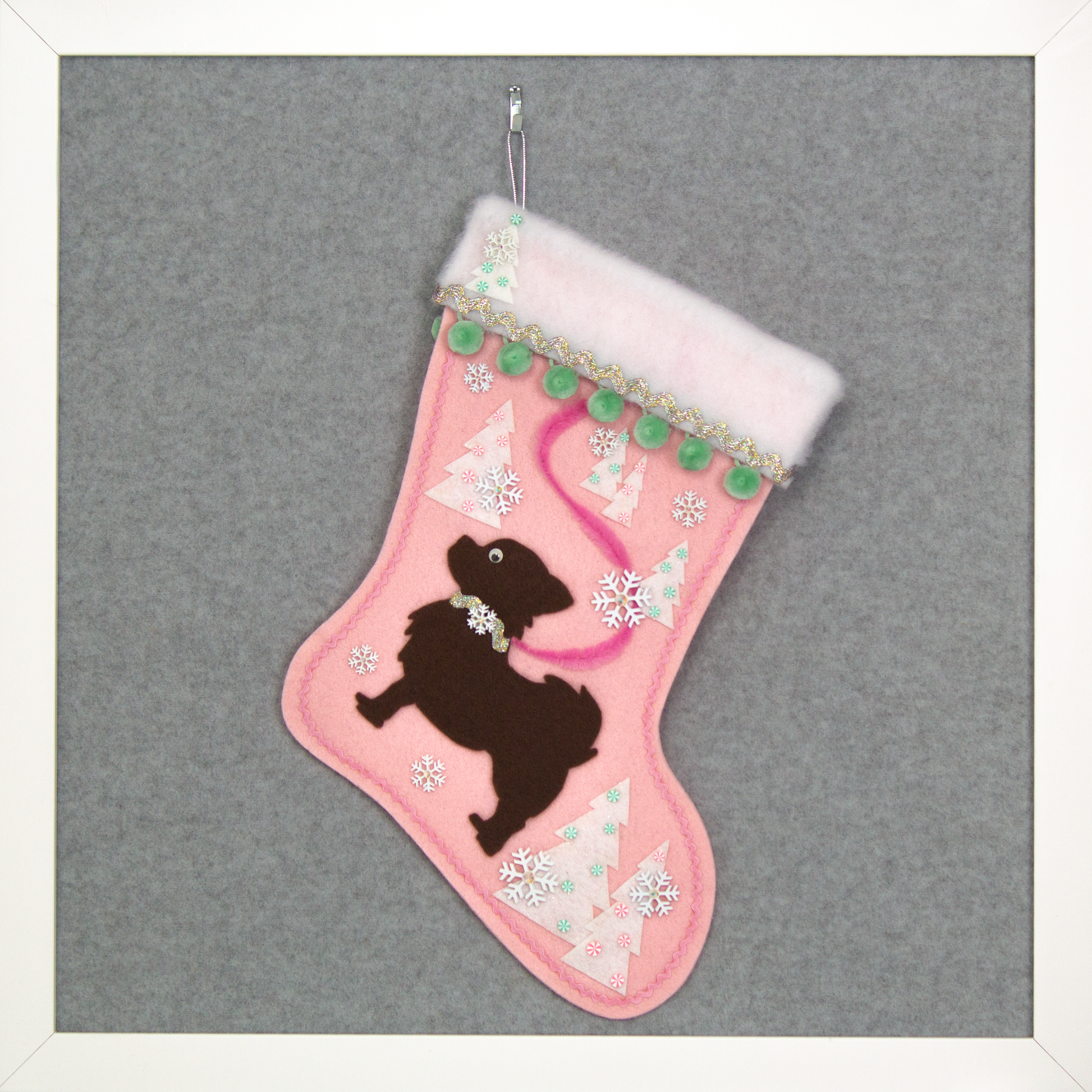 Chocolate brown long hair Chihuahua dog silhouette on a light pink felt Christmas stocking with pom poms, trees, snowflakes and decorations in mint green, pink, white and silver. (front of stocking)