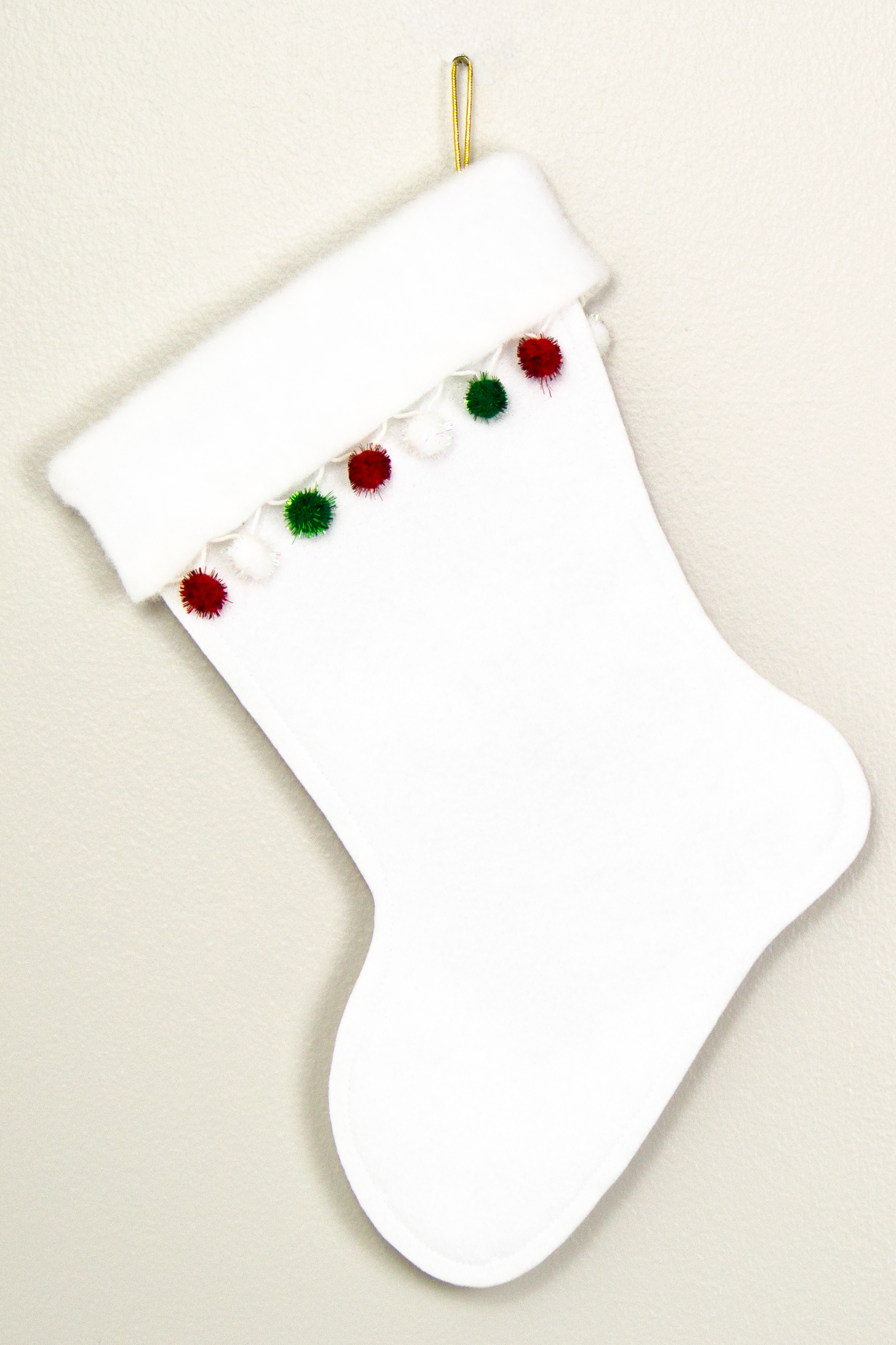 White glitter Christmas stocking with  sparkly pom poms and decorations in green, red and gold. (back of long hair Chihuahua dog stocking)