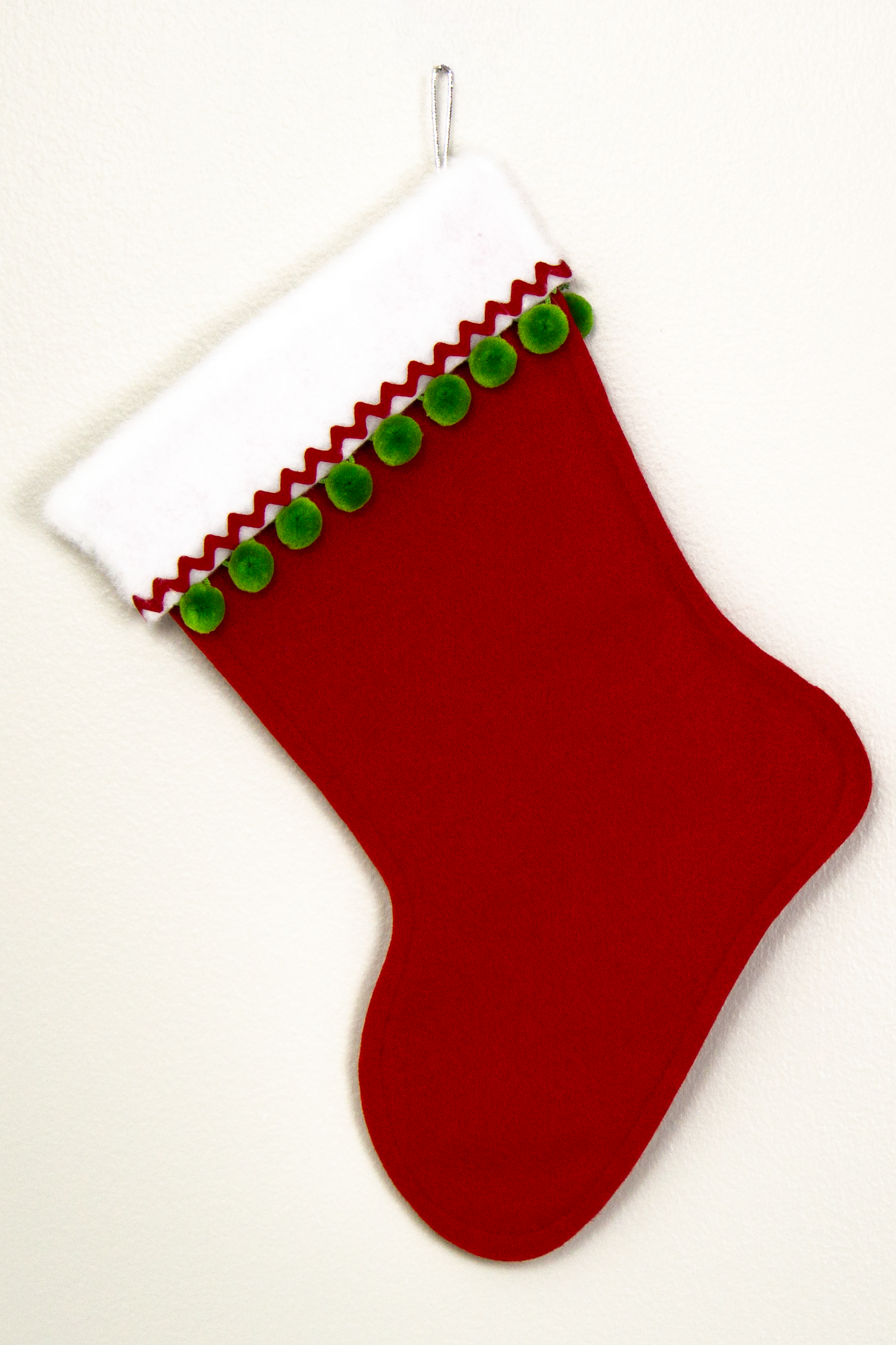 Red glitter Christmas stocking with pom poms and decorations in green, red and silver. (back of long hair Chihuahua dog stocking)