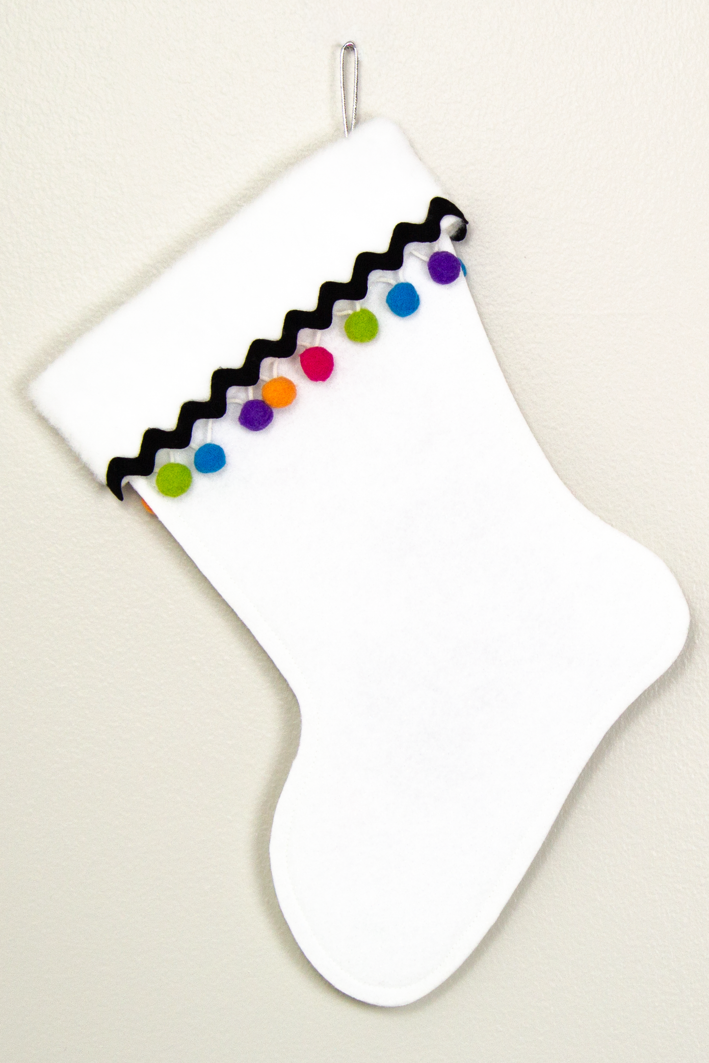 White glitter Christmas stocking with pom poms and decorations in black, silver, hot pink, lime green, orange, purple and blue. (back of long hair Chihuahua dog  stocking)
