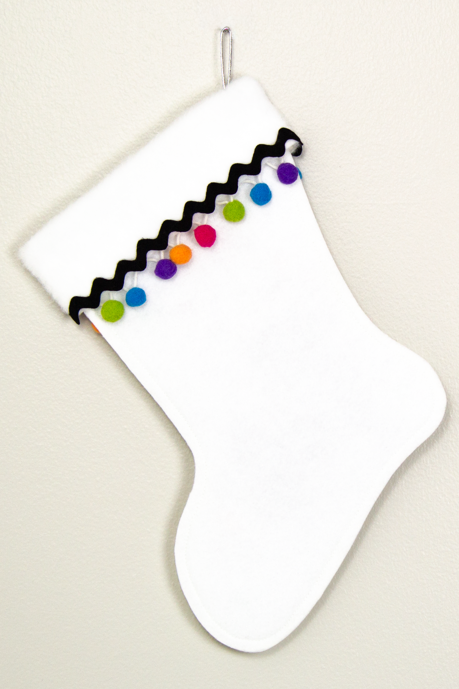 White glitter Christmas stocking with pom poms and decorations in black, silver, hot pink, lime green, orange, purple and blue. (back of long hair Chihuahua dog  stocking)