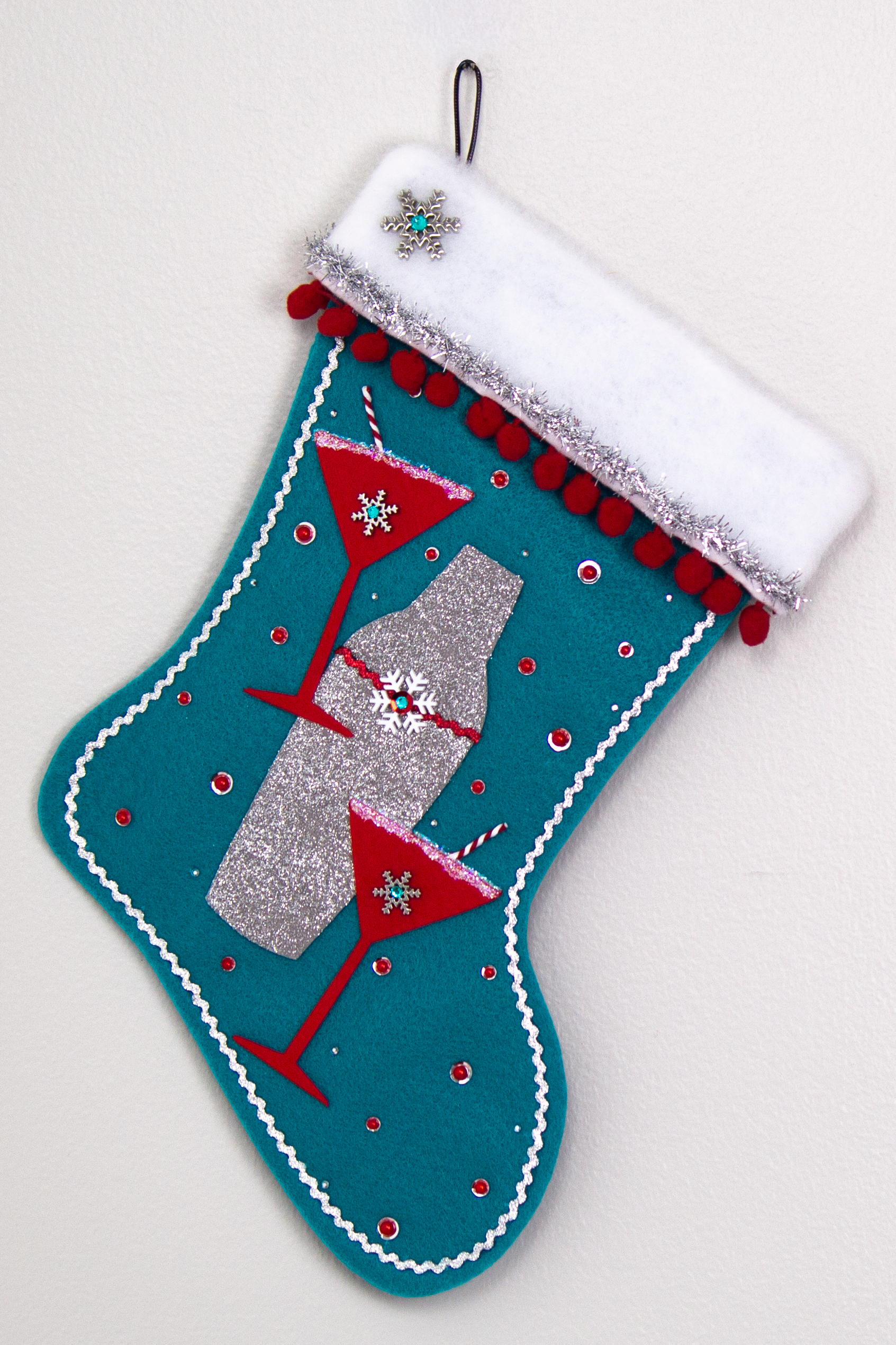 Holiday red felt martini glasses, silver glitter painted gray felt shaker on turquoise felt handmade Christmas stocking with snowflake buttons, pom poms, tinsel ribbon and decorated in  red, turquoise, white & silver. (front of Cocktail stocking)