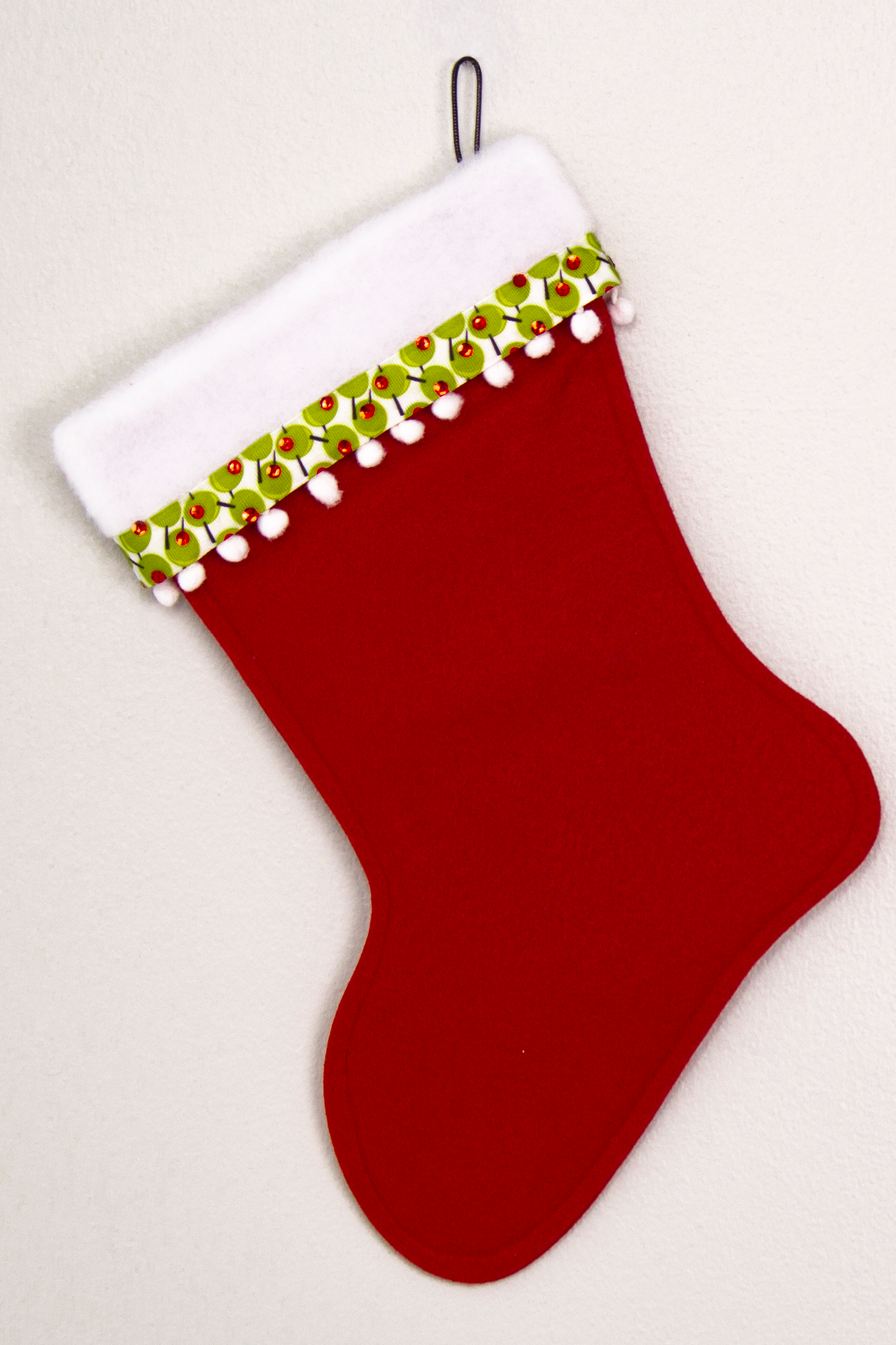 Holiday red felt handmade Christmas stocking with pom poms, olive ribbon and decorated in green, red, white, black & silver. (back of Cocktail stocking)