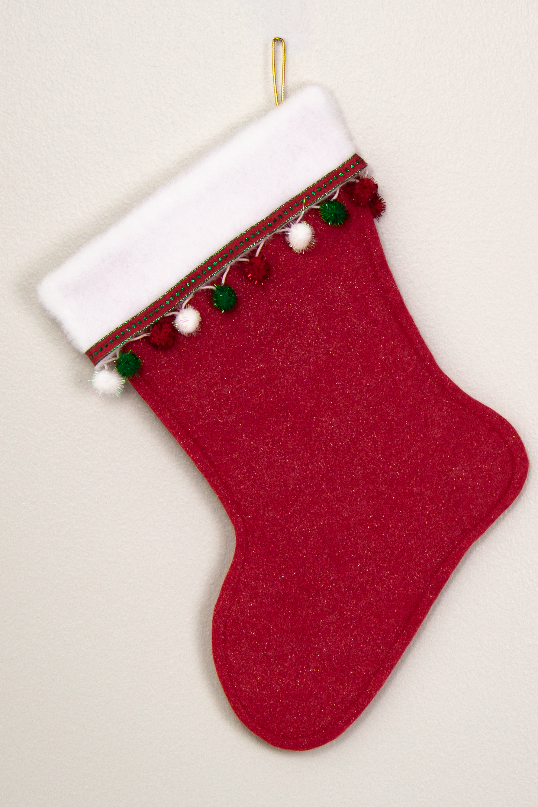 Glitter red felt Christmas stocking with  pom poms and decorated in white, green, red and gold. (back of Corgi dog stocking)