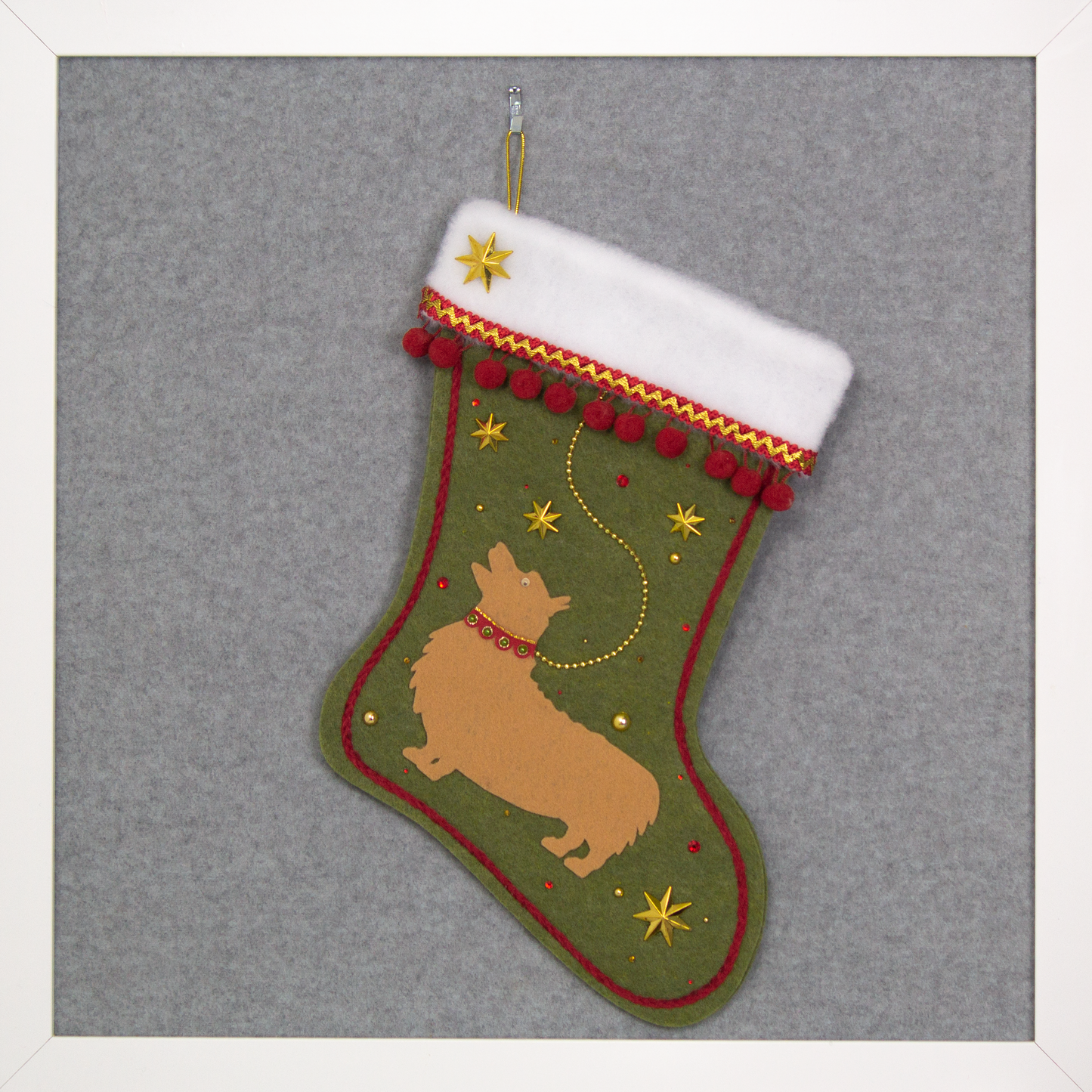 Tan Corgi dog on olive green felt Christmas stocking with stars and pom poms and decorated in gold and red. (front of stocking)
