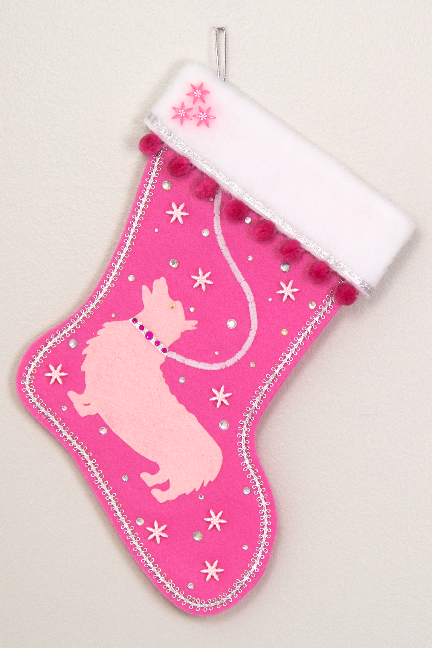 Candy pink Christmas stocking with a Corgi dog design in light pink felt, with silver, white and pink decoration. (front of stocking)