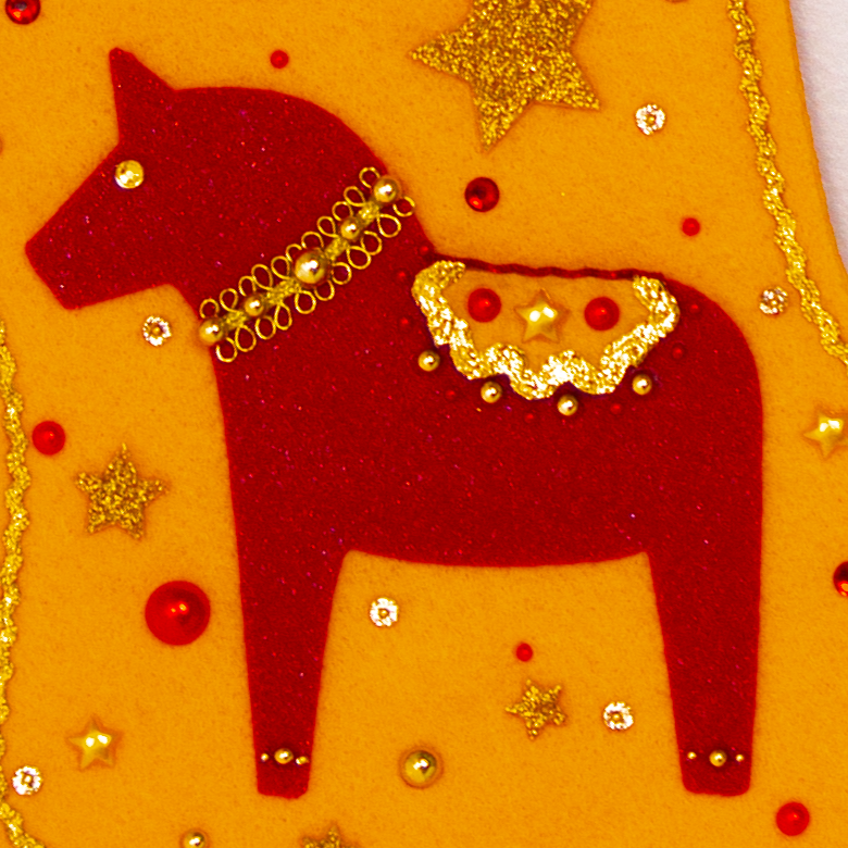 Red glitter Dala horse on gold felt handmade Christmas stocking with sparkly pom poms, gold glittered felt stars and decorated in red & gold. (front of stocking - close up detail of Dala horse)
