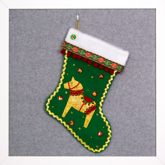 Gold glittered Dala horse on holiday green felt handmade Christmas stocking with pom poms, decorative ribbon, sunburst sequins and decorated in gold, red & green. (front of stocking)