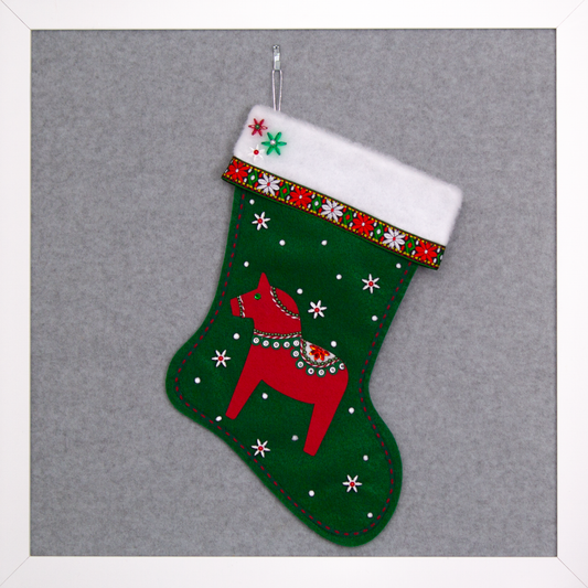 Red Dala horse on dark green felt handmade Christmas stocking with decorative ribbon, flower beads and decorated in red, green, white & silver. (front of stocking)