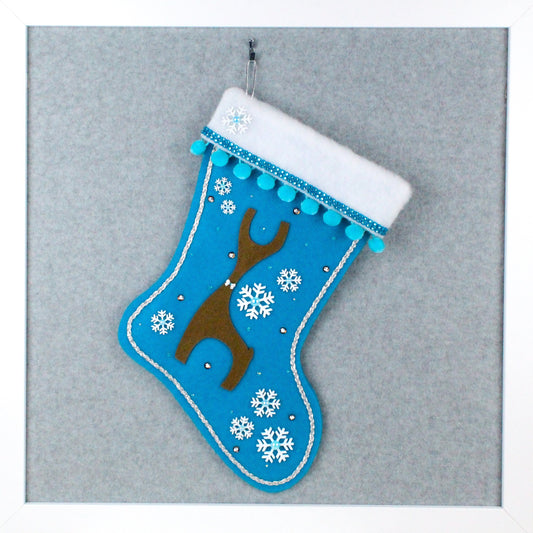 Brown Danish reindeer on peacock blue felt one of a kind handmade Christmas stocking with white snowflakes, blue pom poms and silver decorations.