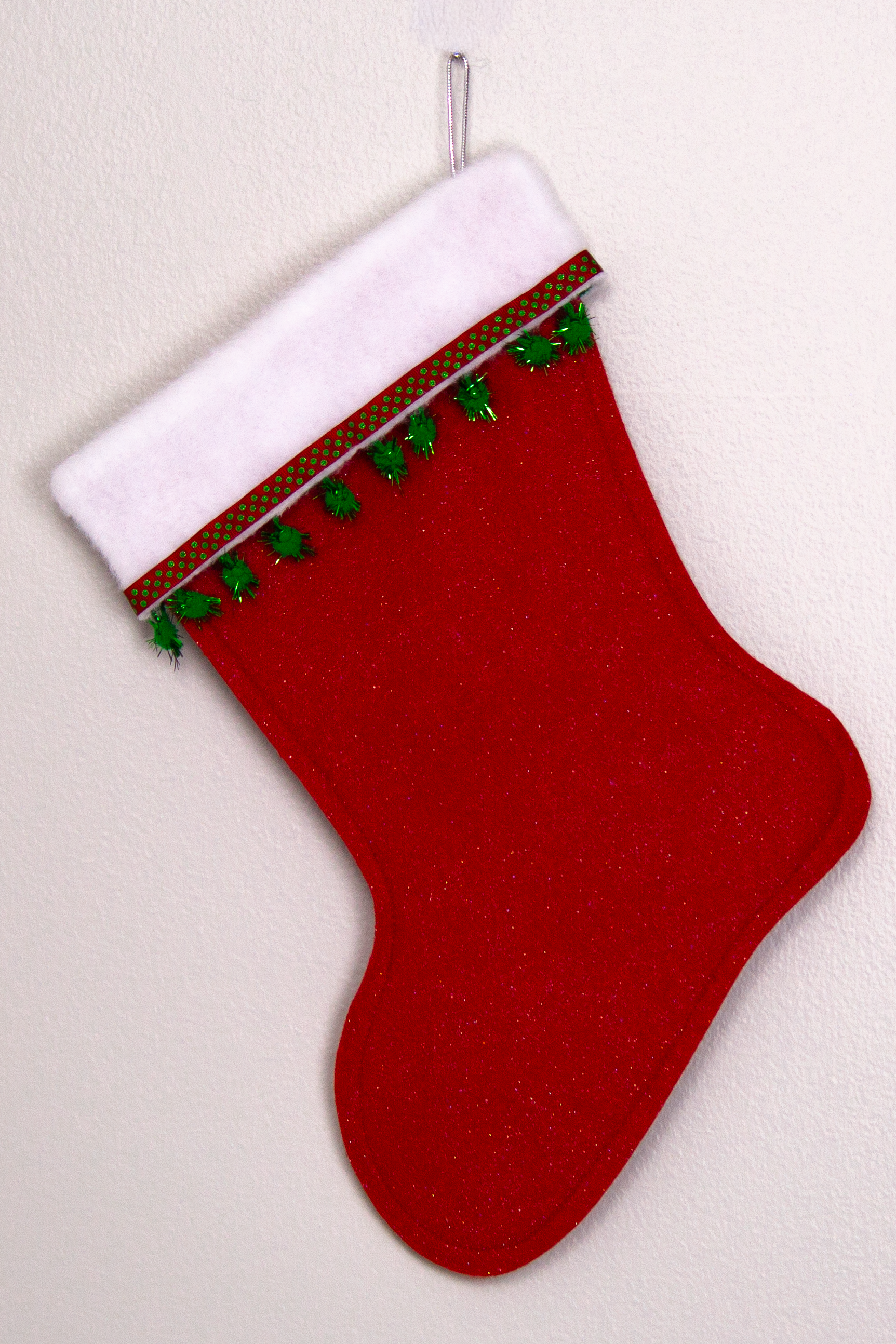 Red glitter felt handmade Christmas stocking with sparkly pom poms and decorated in green & silver. (back of Flamingo stocking)