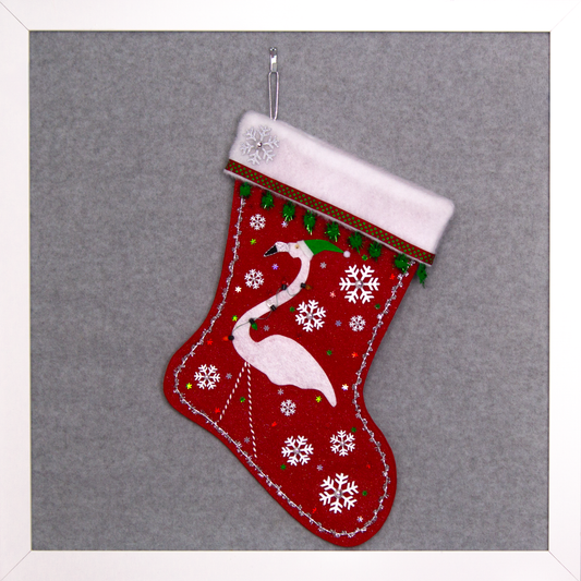 White glitter felt flamingo on red glitter felt handmade Christmas stocking with sparkly pom poms, snowflake buttons, fake lights and decorated in white, green, red & silver. (front of stocking)