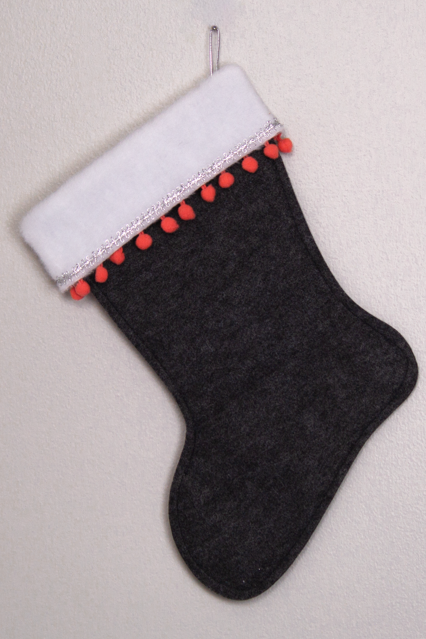 Charcoal gray felt handmade Christmas stocking with pom poms and decorated in coral & silver. (back of Flamingo  stocking)