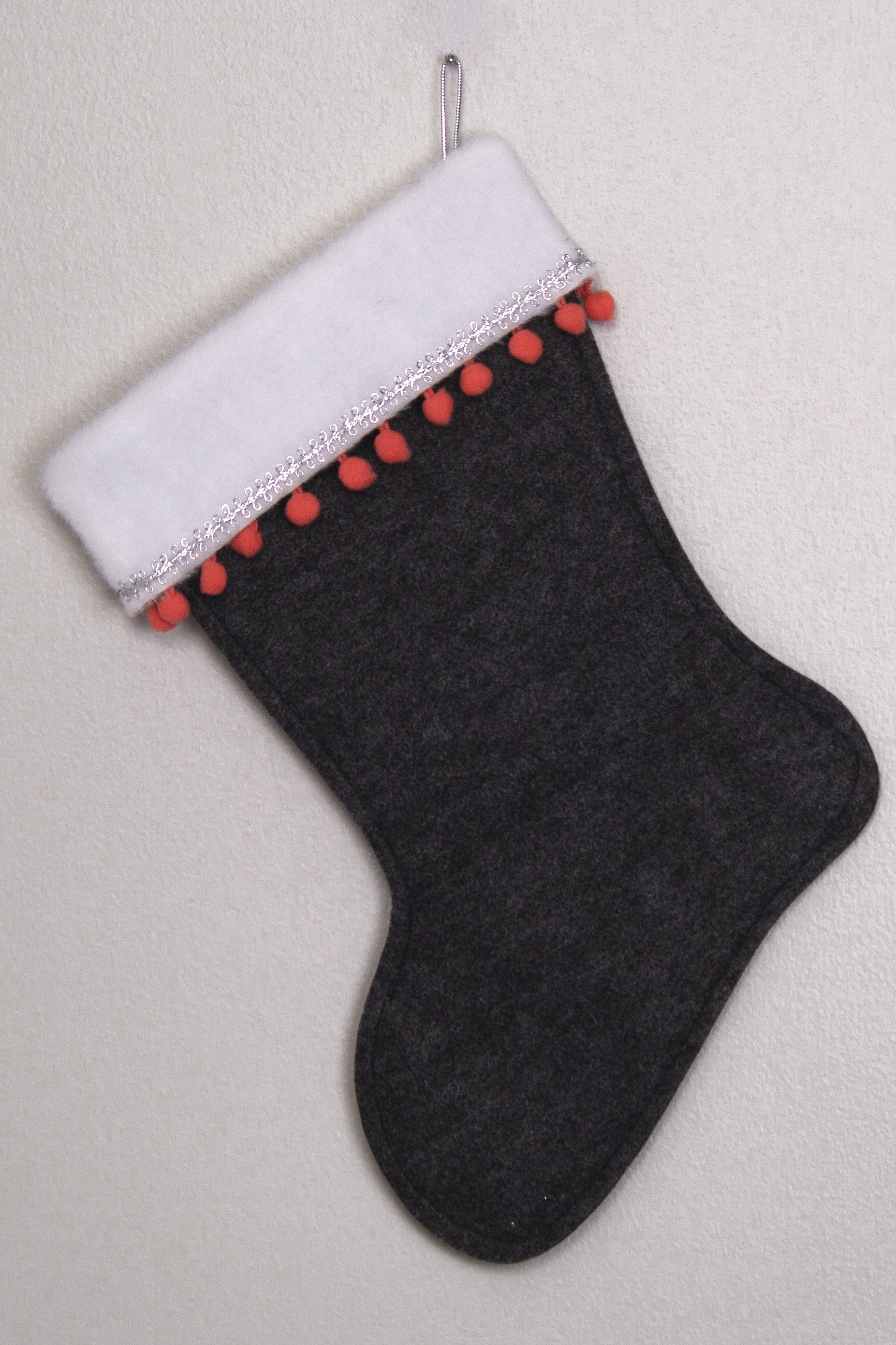Charcoal gray felt handmade Christmas stocking with pom poms and decorated in coral & silver. (back of Flamingo  stocking)