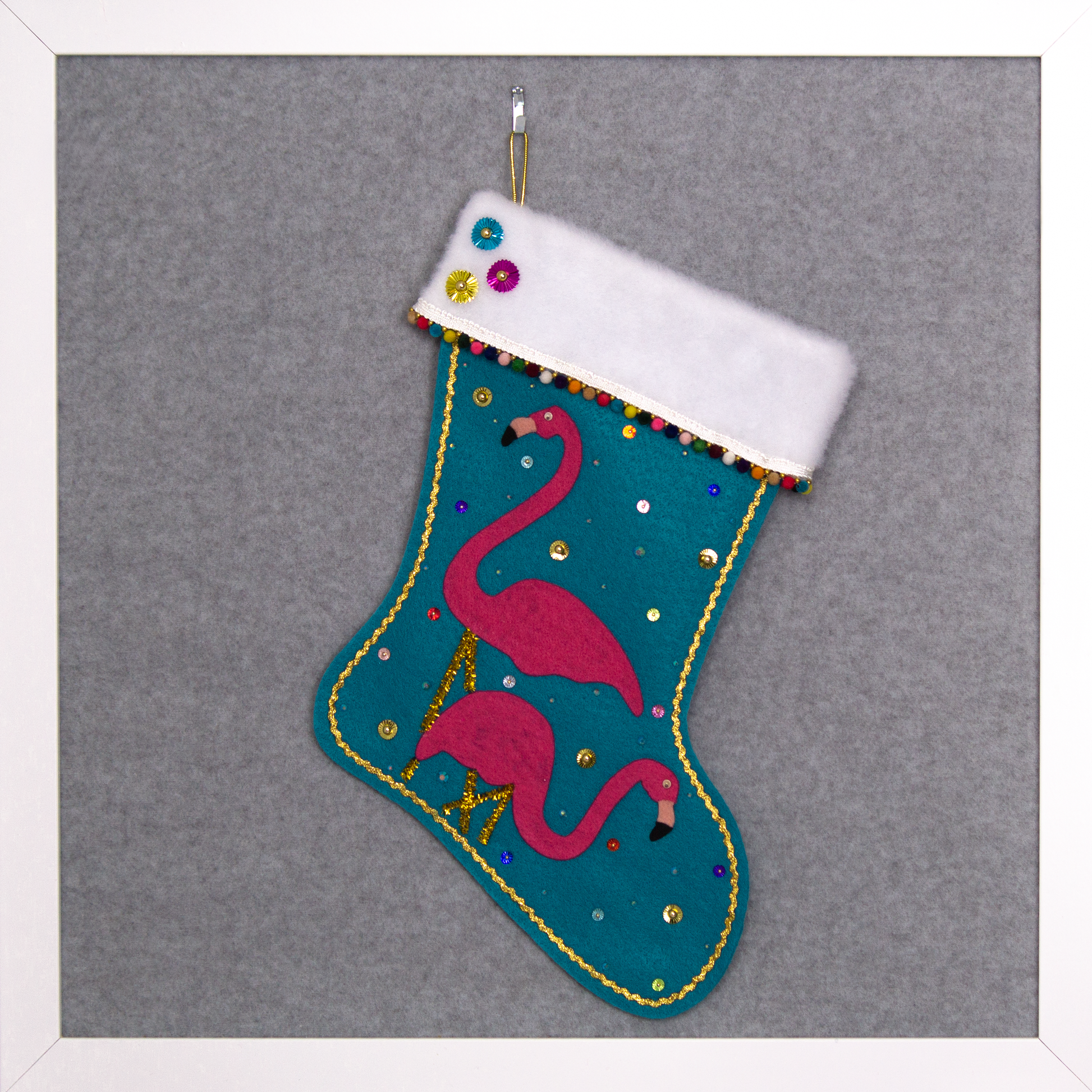 Shocking pink flamingos on turquoise felt handmade Christmas stocking with mini pom poms, sunburst sequins and decorated in gold & multicolors. (front of stocking)