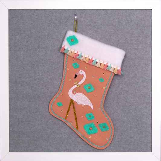 White glittery flamingo on coral felt handmade Christmas stocking with glitter painted felt onion ornament shapes, tassel fringe and decorated in coral, aqua, gold & pastel colors. (front of Flamingo stocking)