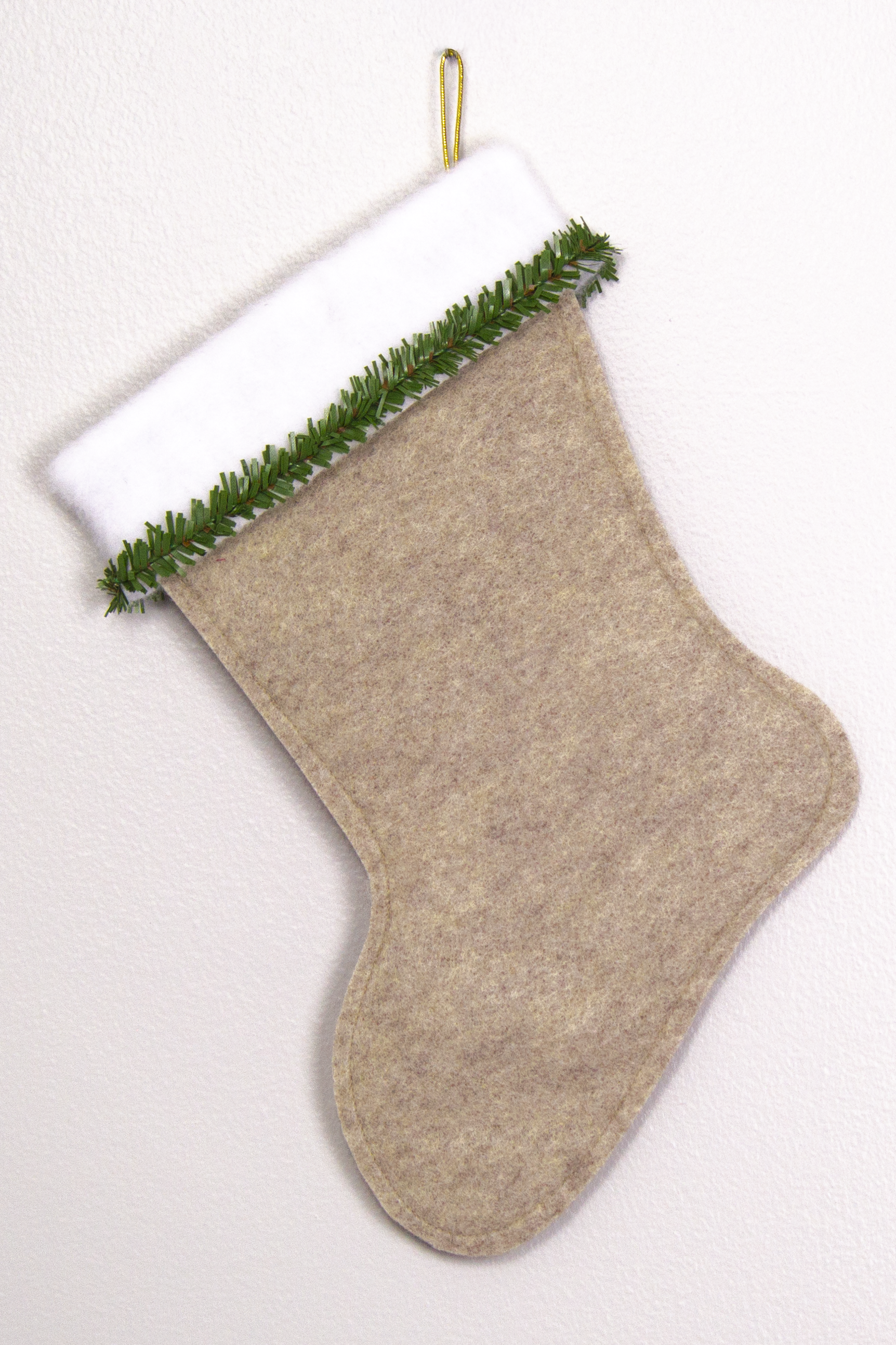 Sandstone beige felt handmade Christmas stocking with faux pine trim and decoration in green and gold. (back of German Shepherd dog stocking)