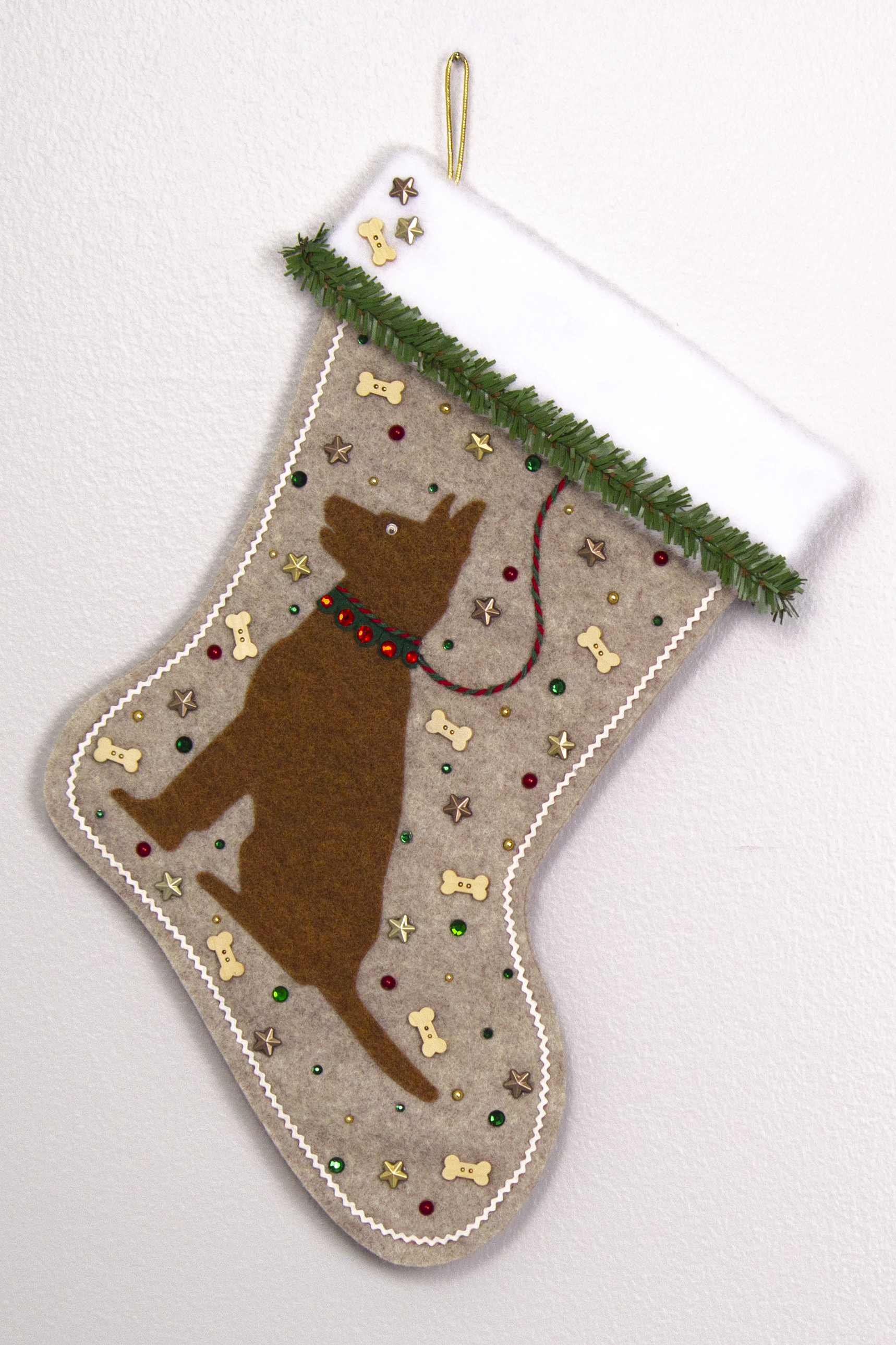Copper German Shepherd dog on sandstone beige felt handmade Christmas stocking with faux pine trim, wood bone buttons, stars and decoration in red, green, white, gold and bronze. (front of stocking)