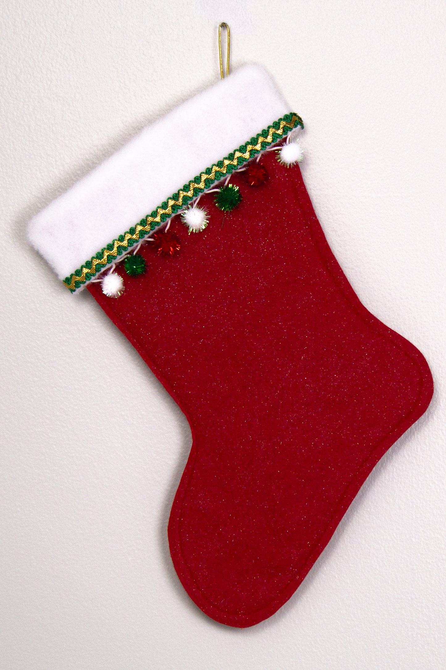 Red glitter felt handmade Christmas stocking with sparkly pom poms and decorated in red, green, white and gold. (back of German Shepherd dog stocking)