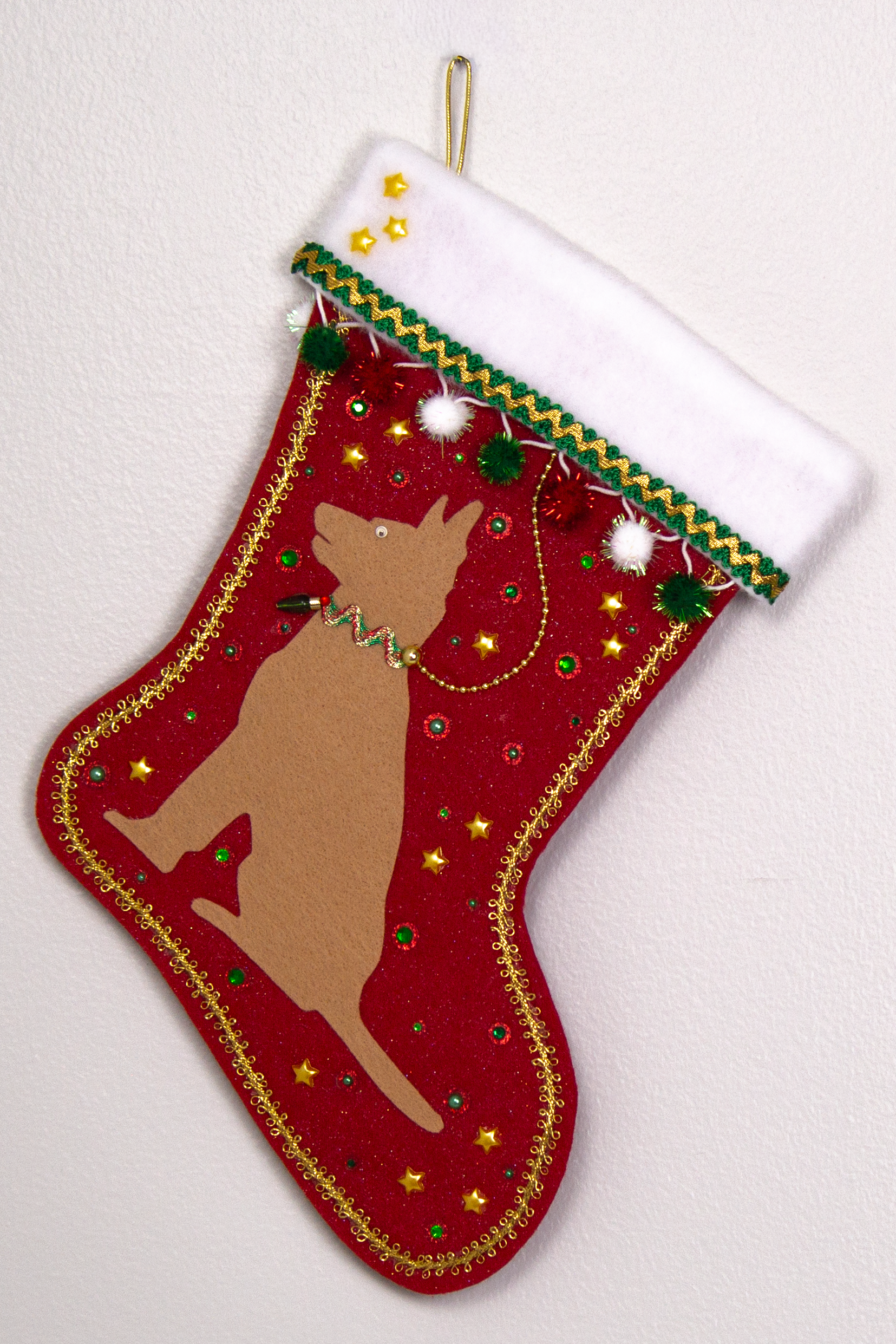 Tan German Shepherd dog on a red glitter felt handmade Christmas stocking with sparkly pom poms, stars and decorated in red, green, white and gold. (front of stocking)