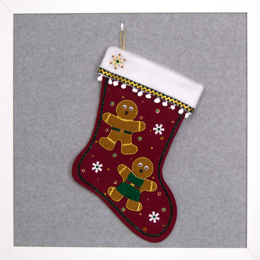 Twin copper felt Gingerbread on a ruby red felt handmade Christmas stocking with pom poms, wood snowflakes and decorated in white, green, red & gold. (front of stocking)