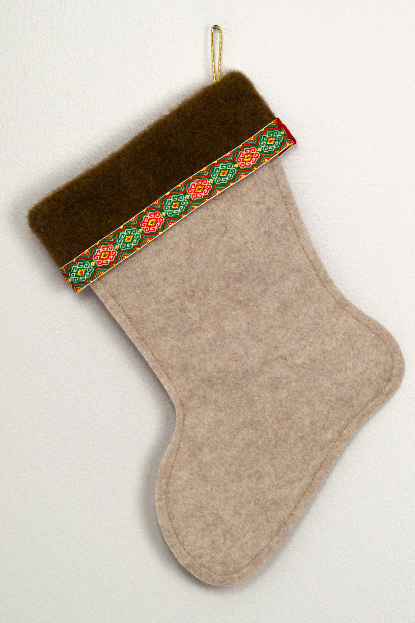Sandstone beige felt handmade Christmas stocking with brown fur trim, decorative ribbon and decorated in red, green & gold. (back of Gingerbread stocking)