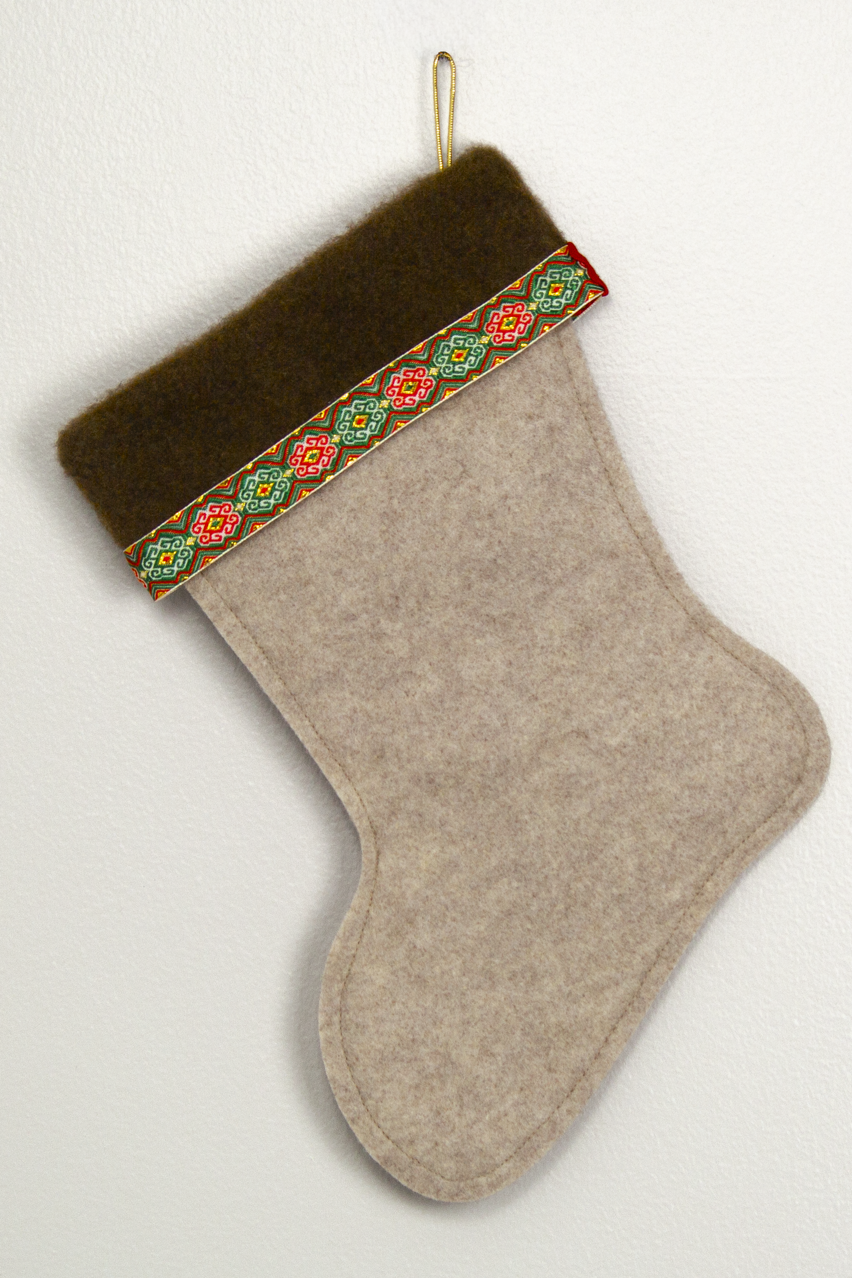 Sandstone beige felt handmade Christmas stocking with brown fur trim, decorative ribbon and decorated in red, green & gold. (back of Gingerbread stocking)