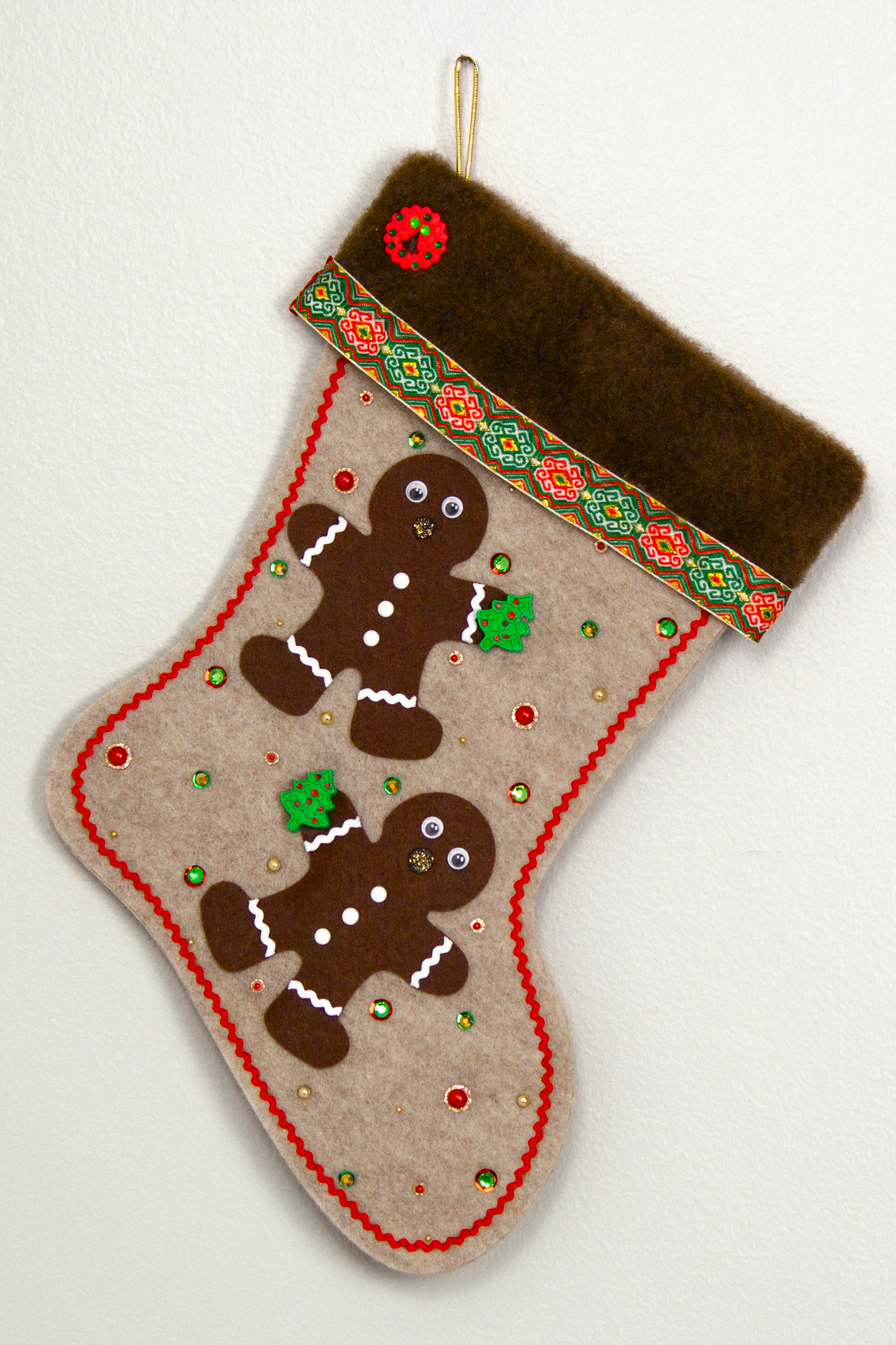 Twin dark brown Gingerbread men on sandstone beige felt handmade Christmas stocking with brown fur trim, decorative ribbon, tree buttons, a wreath button and decorated in red, green, white & gold. (front of stocking)