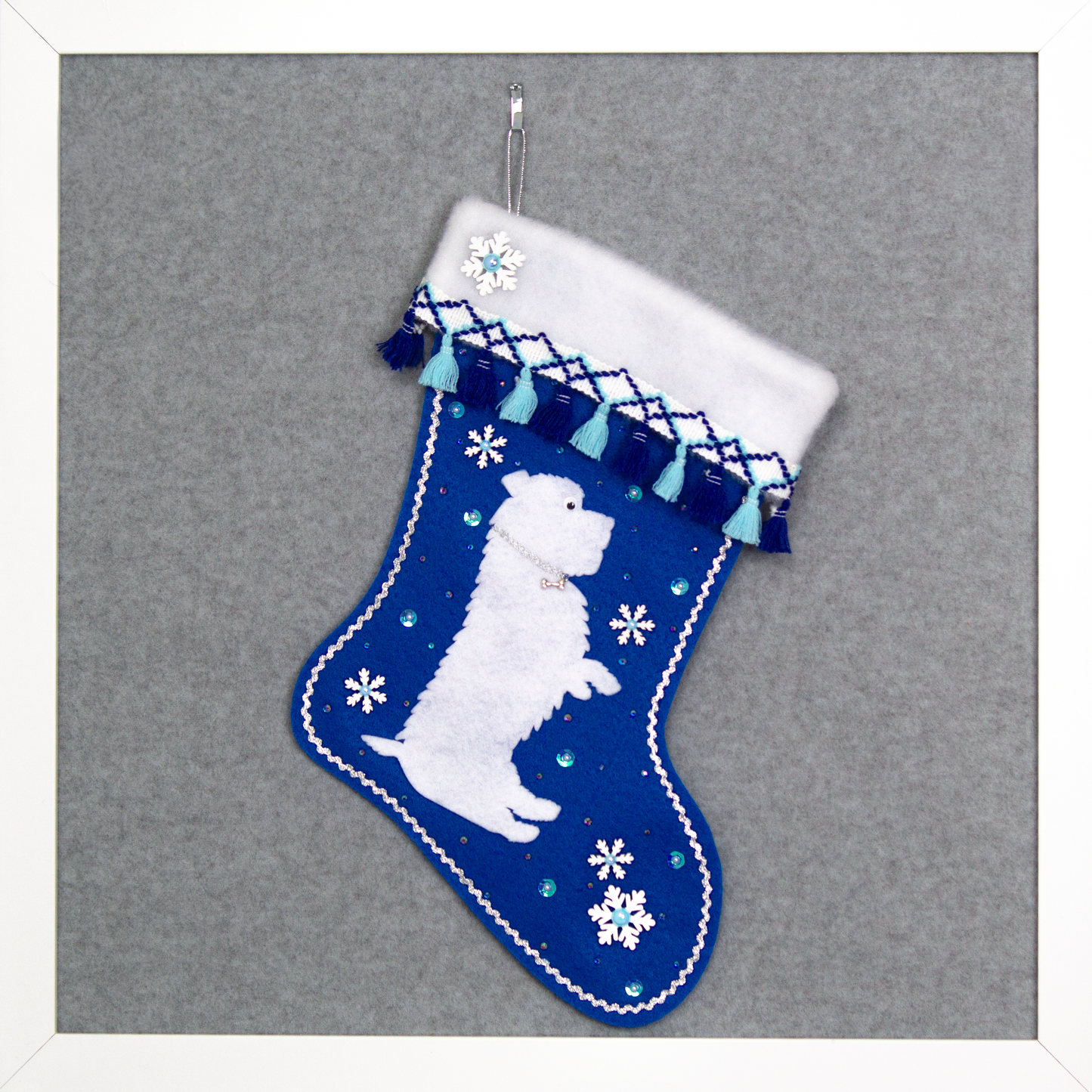White Glen of Imaal Terrier dog on royal blue felt handmade Christmas stocking with fringe, wood snowflakes and decoration in silver, white and blues. (front of stocking)