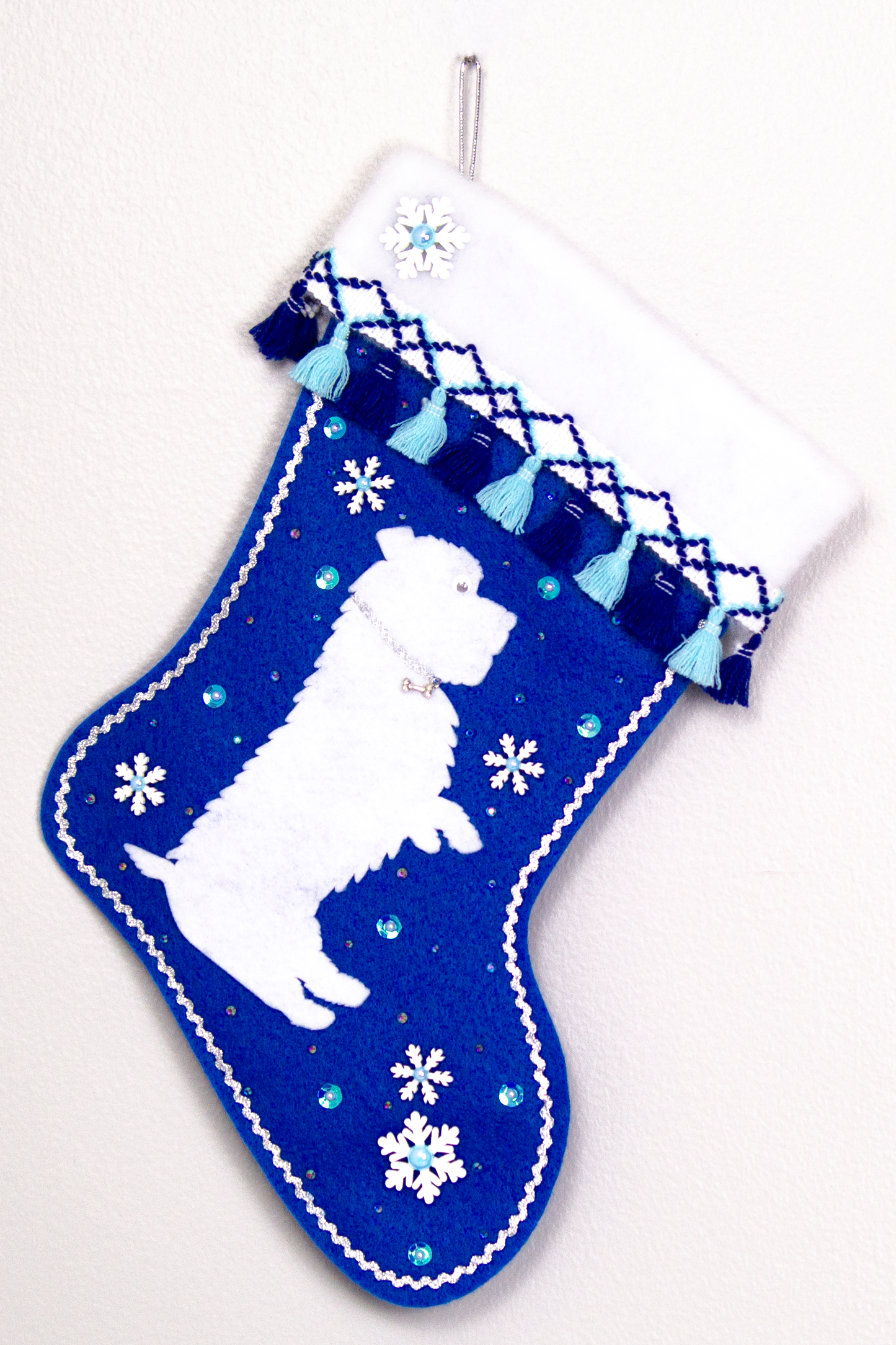 White Glen of Imaal Terrier dog on royal blue felt handmade Christmas stocking with fringe, wood snowflakes and decoration in silver, white and blues. (front of stocking)