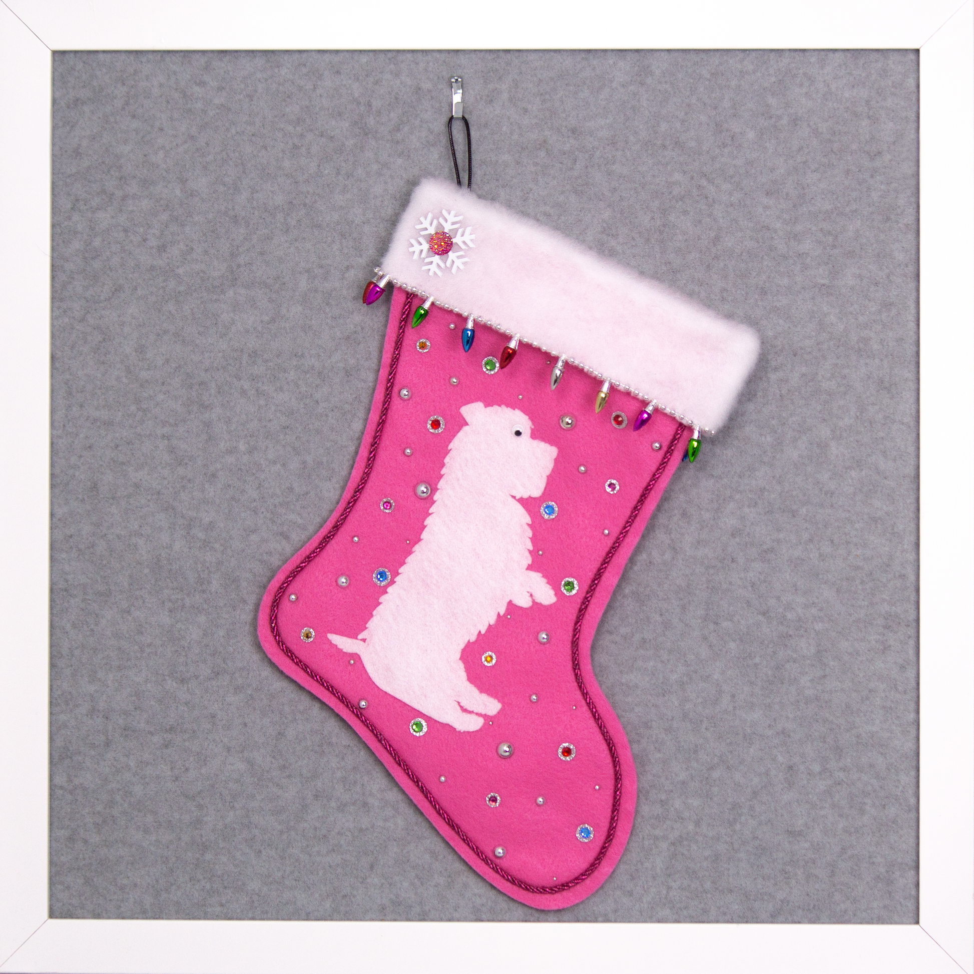 White Glen of Imaal Terrier dog on candy pink felt handmade Christmas stocking with light bulb trim, a snowflake, and decoration in silver and multicolors. (front of stocking)