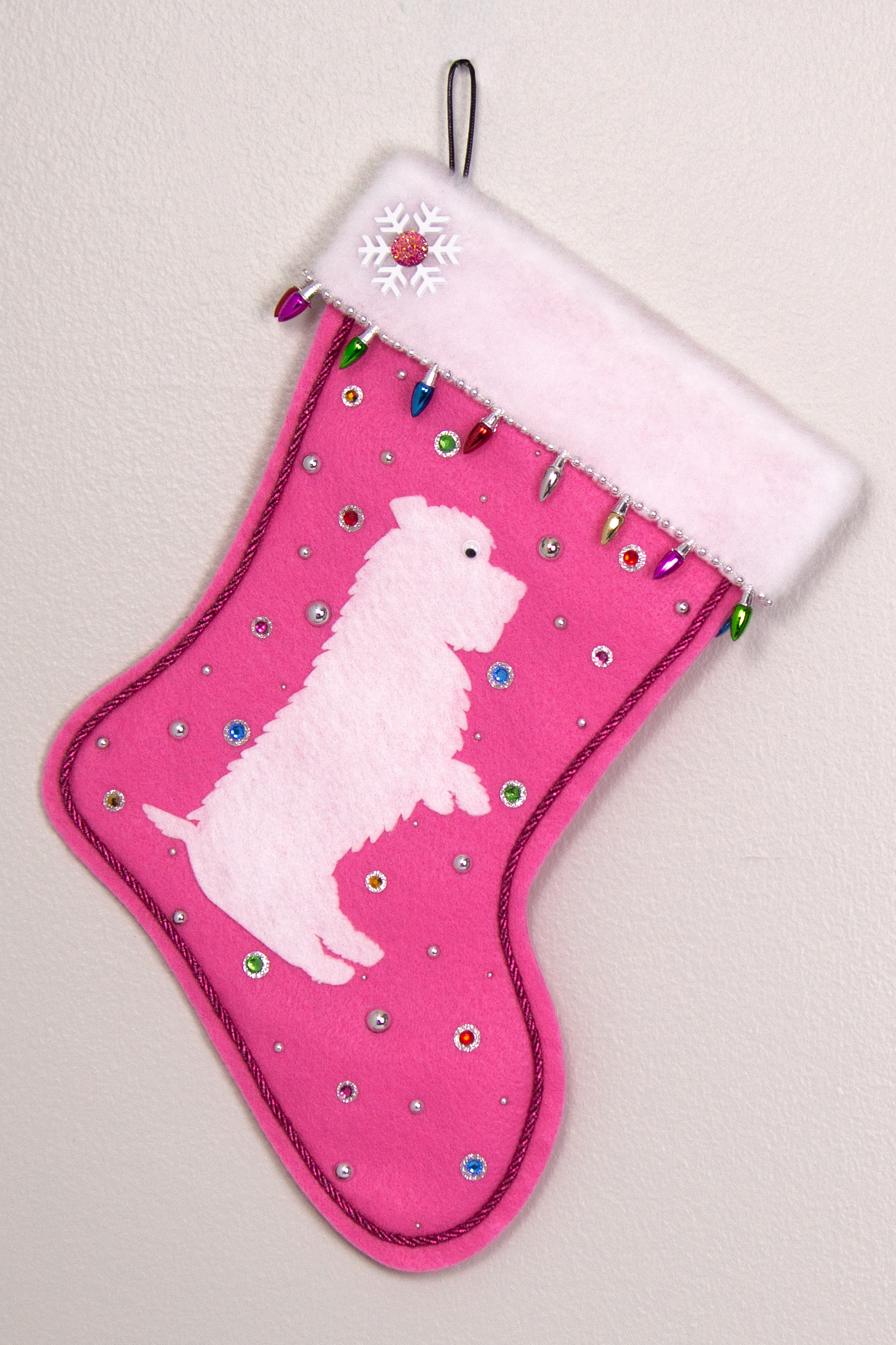 White Glen of Imaal Terrier dog on candy pink felt handmade Christmas stocking with light bulb trim, a snowflake, and decoration in silver and multicolors. (front of stocking)