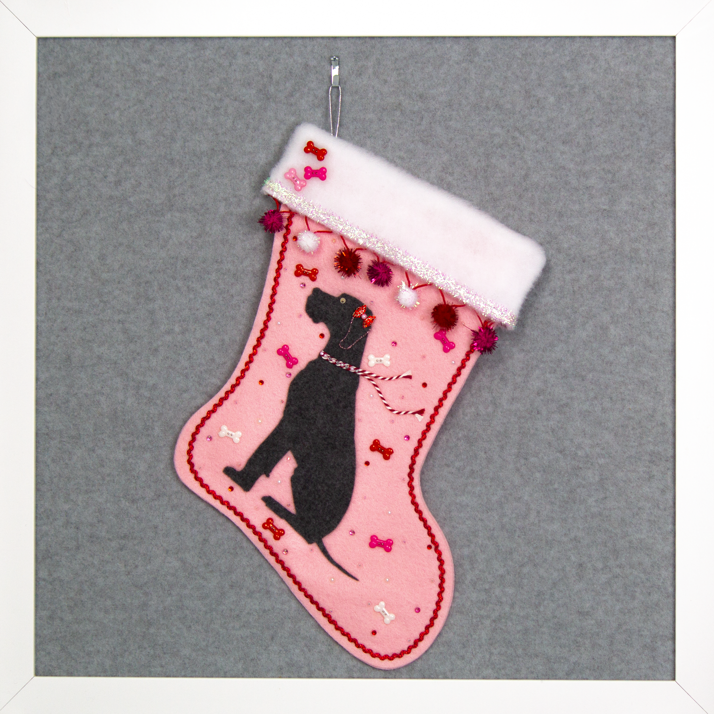 Charcoal gray Great Dane dog on light pink felt handmade Christmas stocking with sparkly pom poms, tinsel, bone buttons and decorated in red, pinks, white and silver. (front of stocking)
