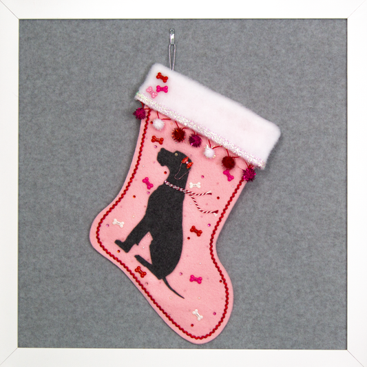 Charcoal gray Great Dane dog on light pink felt handmade Christmas stocking with sparkly pom poms, tinsel, bone buttons and decorated in red, pinks, white and silver. (front of stocking)