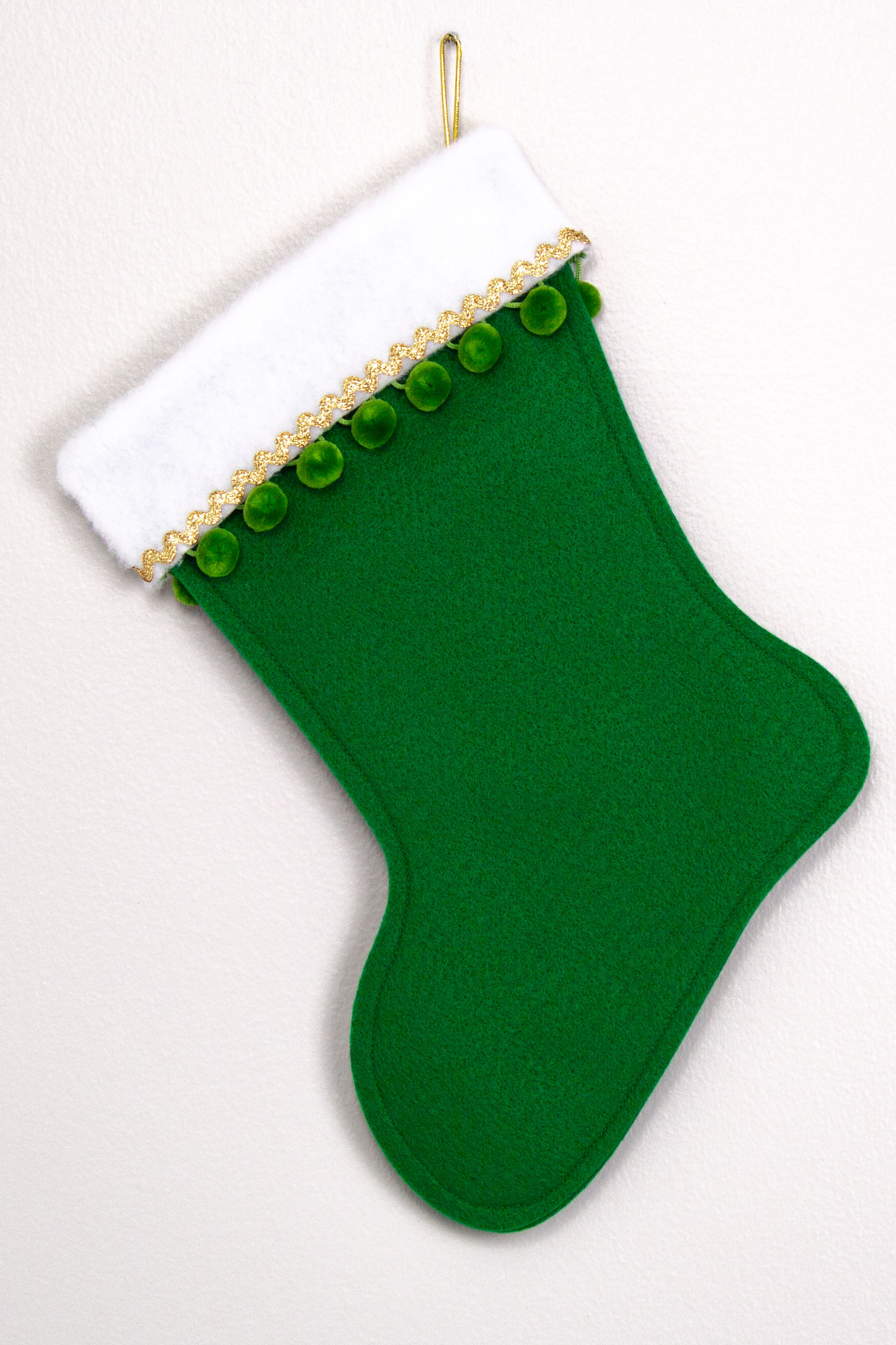 Holiday green felt handmade Christmas stocking with pom poms and decoration green & gold. (back of Narwhal stocking)