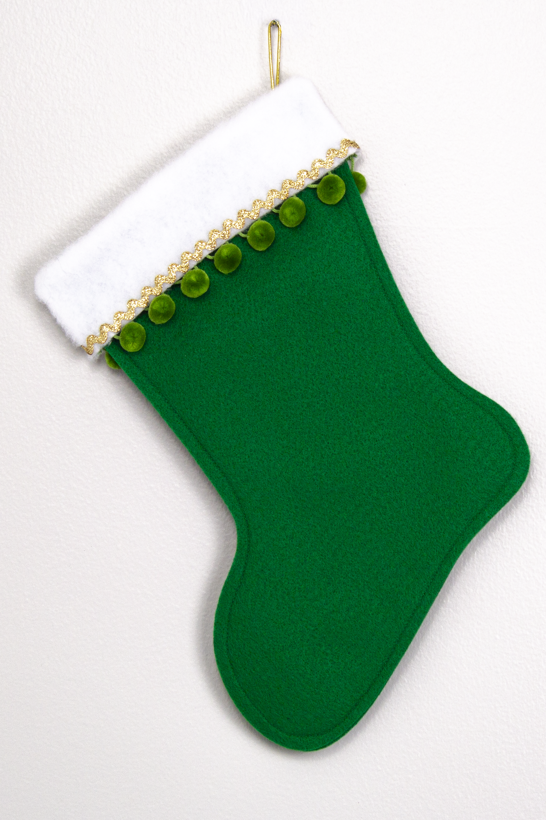 Holiday green felt handmade Christmas stocking with pom poms and decoration green & gold. (back of Narwhal stocking)