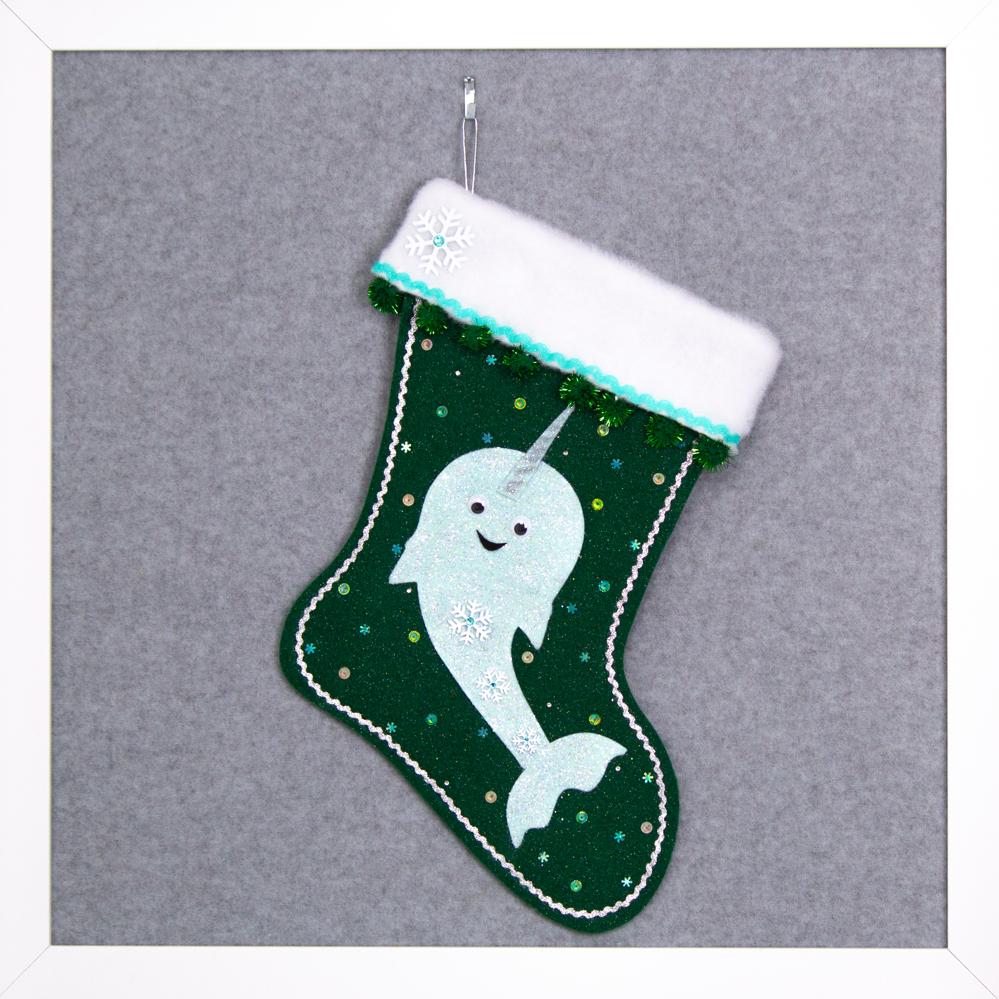Mint green glittered Narwhal on dark green glitter felt handmade Christmas stocking with sparkly dark green pom poms, snowflake buttons and decorations in aqua, silver and multicolors. (front of stocking)