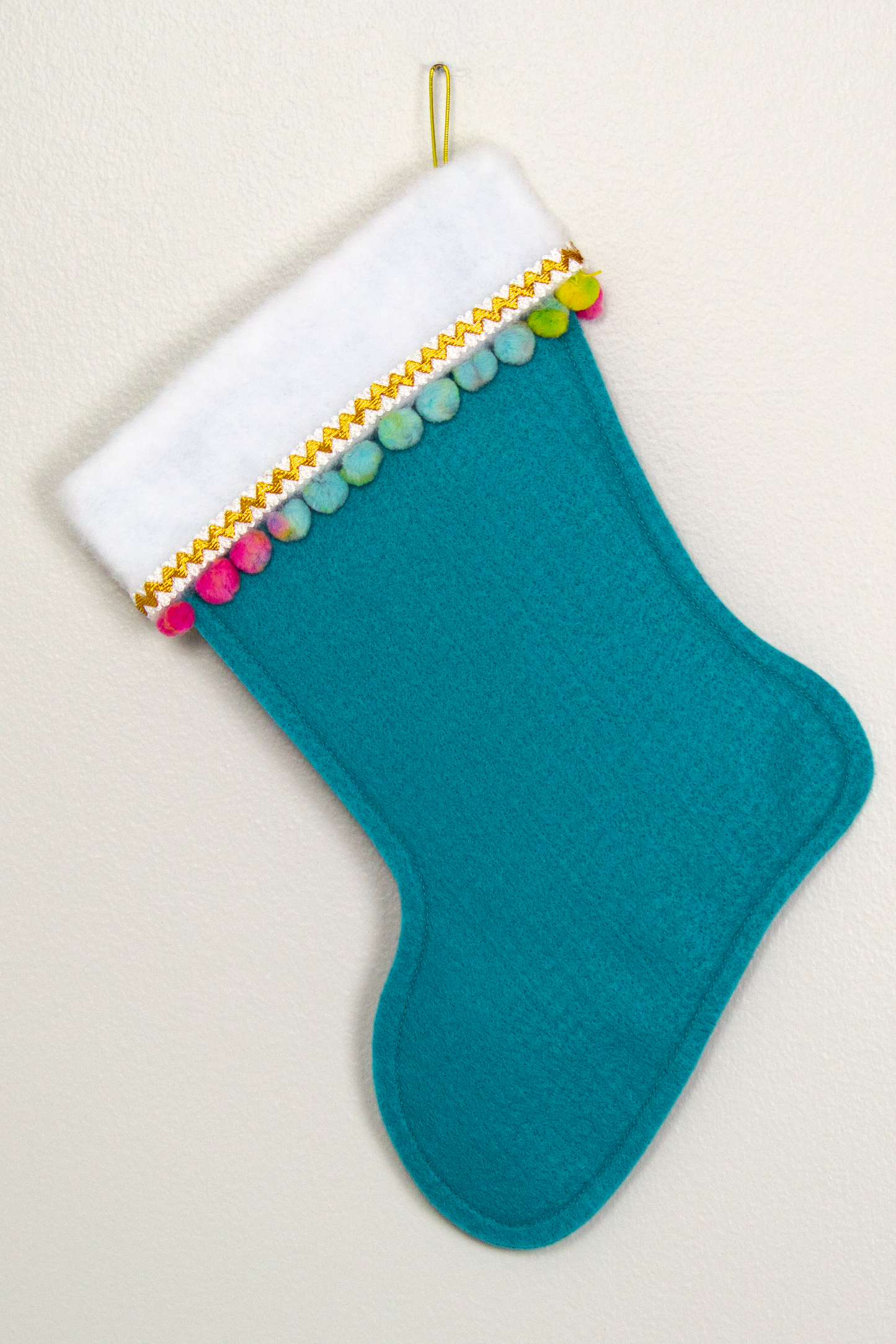 White Pomeranian dog on turquoise felt Christmas stocking