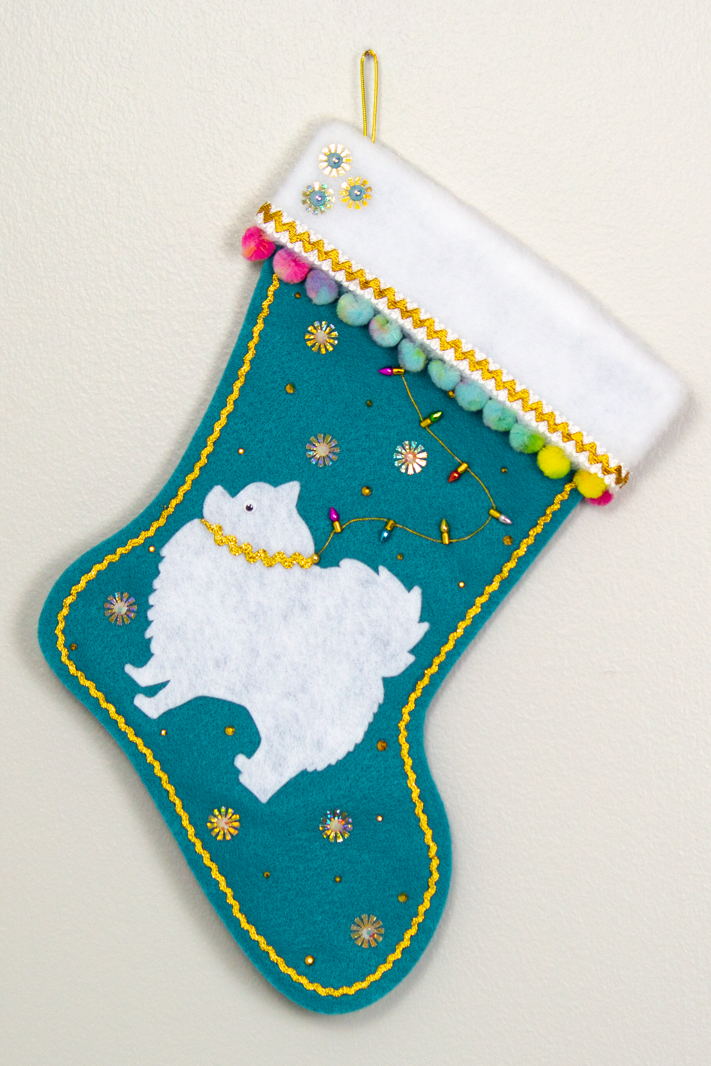White Pomeranian dog on turquoise felt Christmas stocking