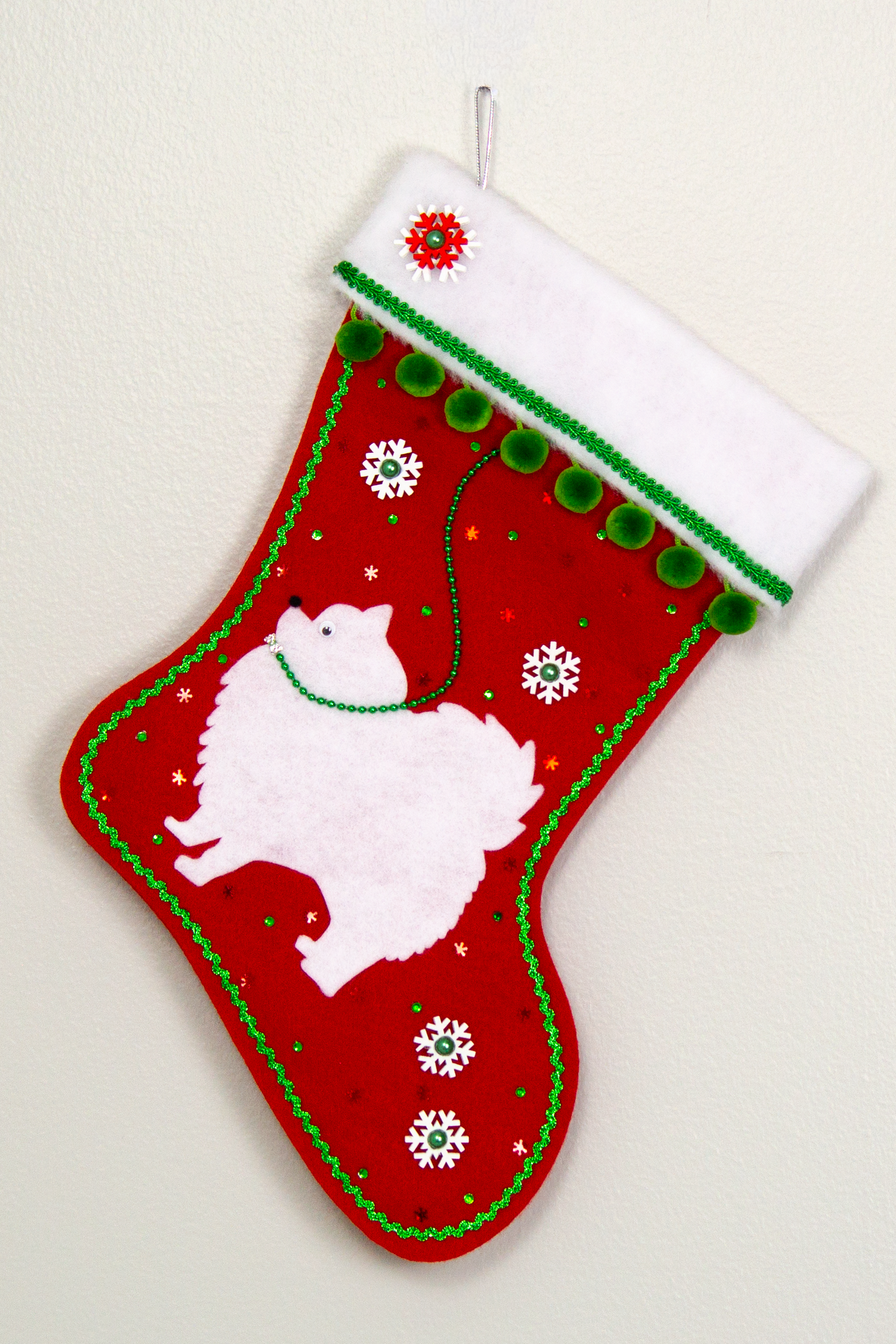 White Pomeranian dog on red felt Christmas stocking