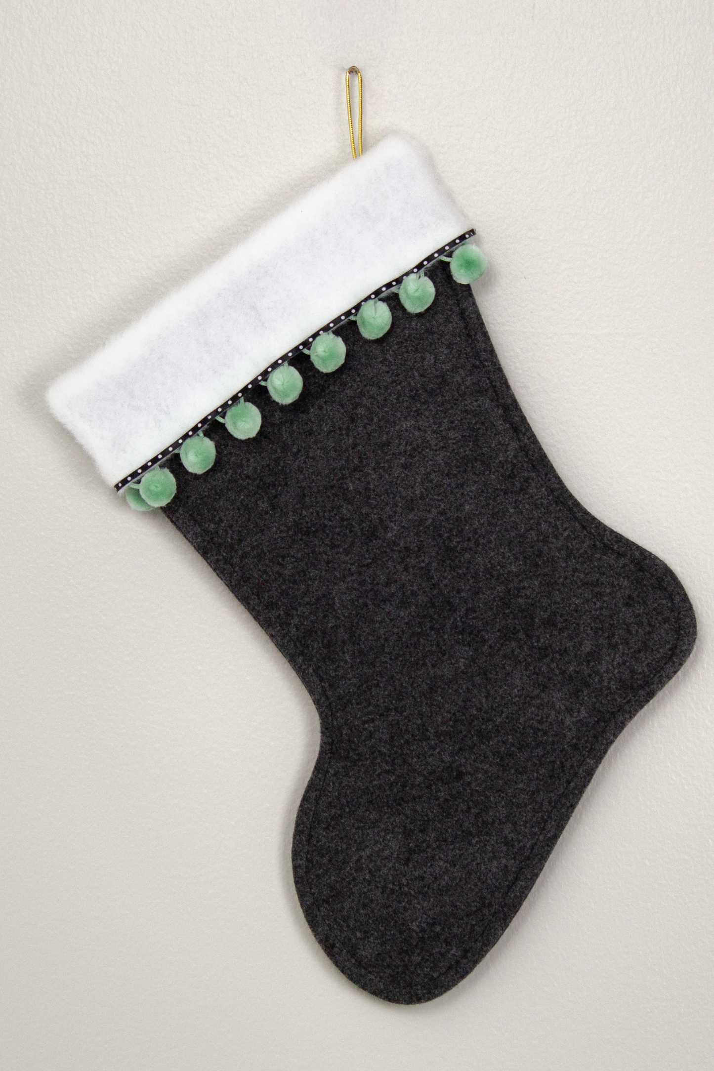 Back of charcoal gray Christmas stocking with white poodle design 