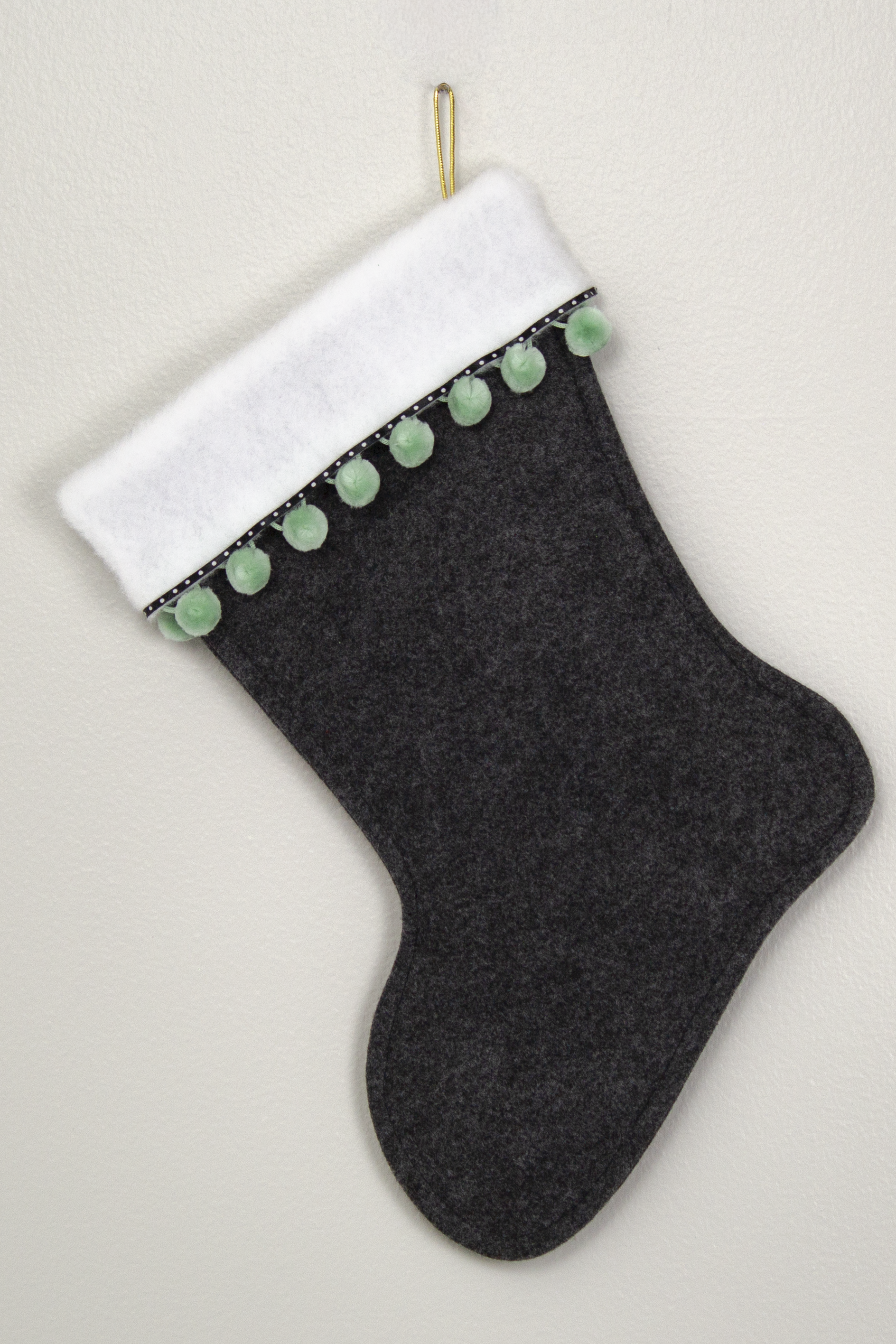 Back of charcoal gray Christmas stocking with white poodle design 